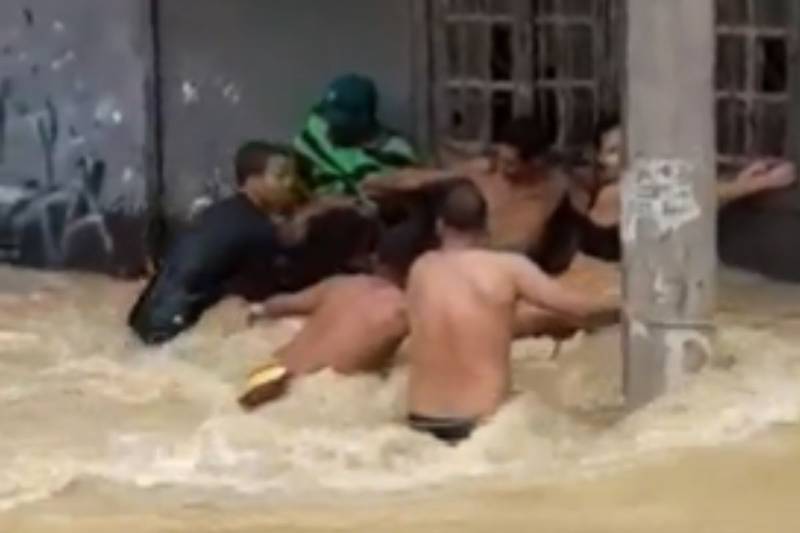 Moradores se agarram à corda para se salvar de enchente