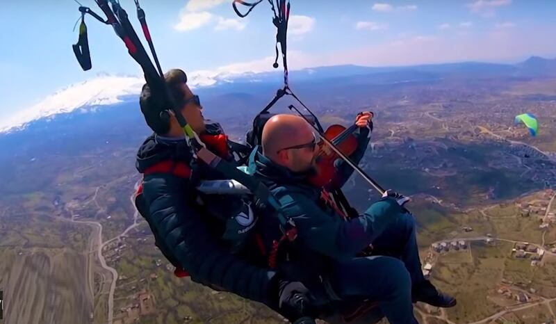 Vídeo: Homem toca violino para relaxar durante voo de parapente; assista