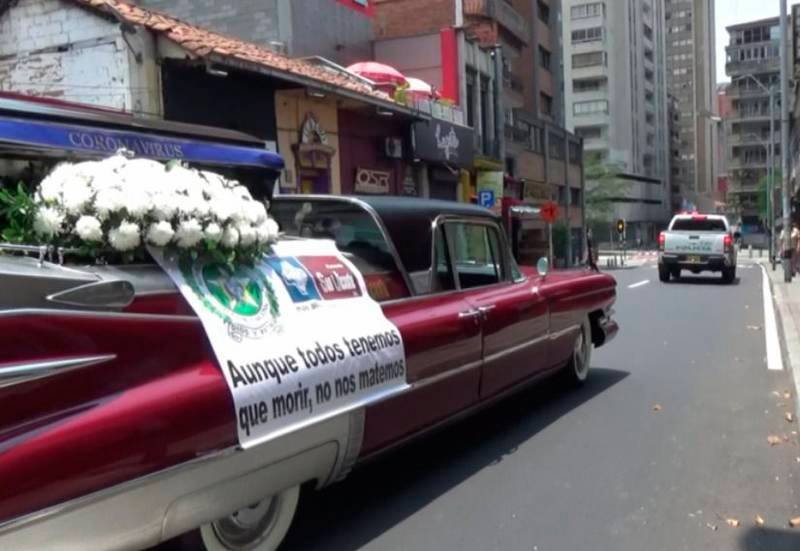 Carro funerário transporta morto nas ruas da Colômbia