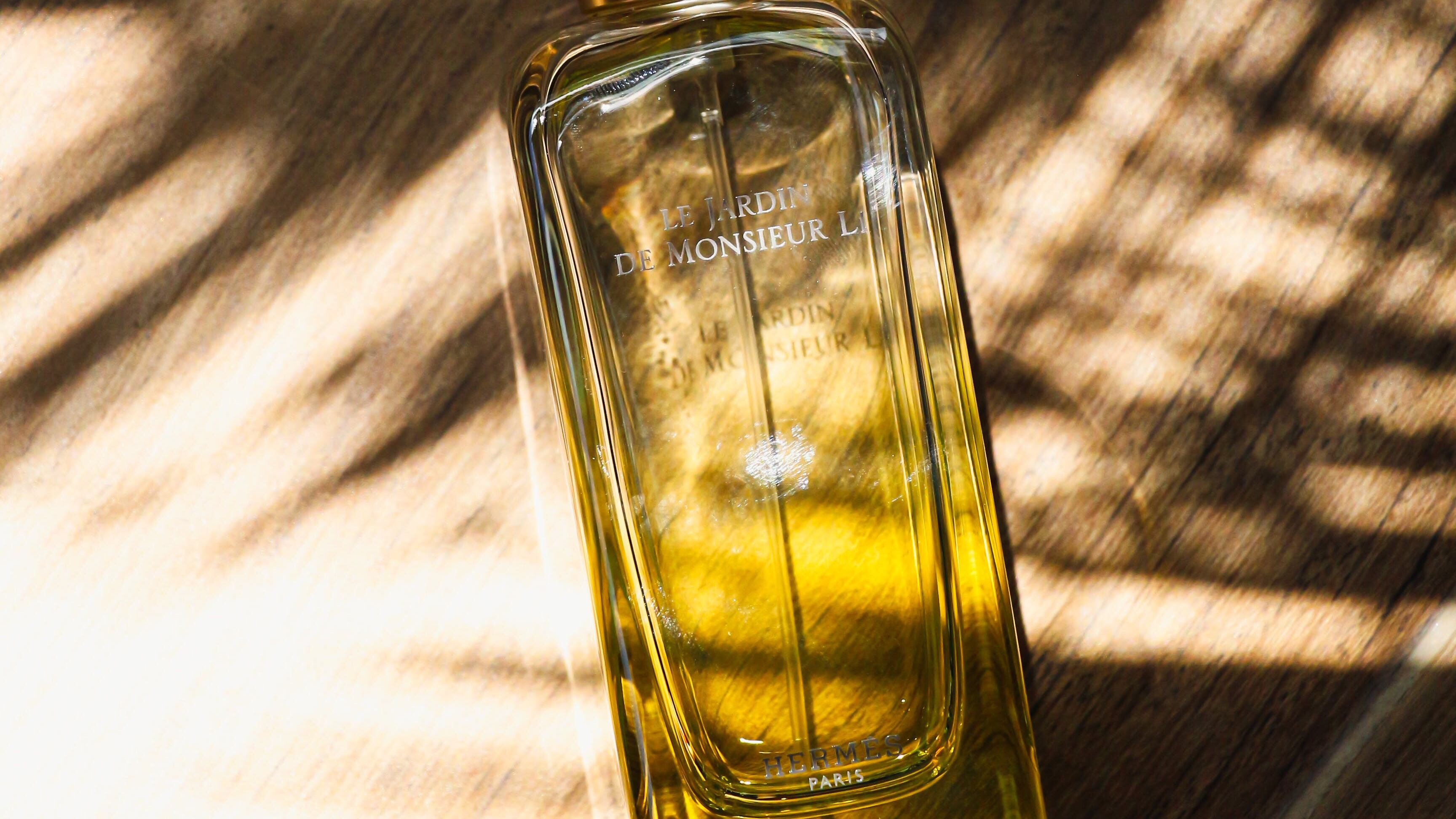 Frasco de perfumes com sombra de palmeiras