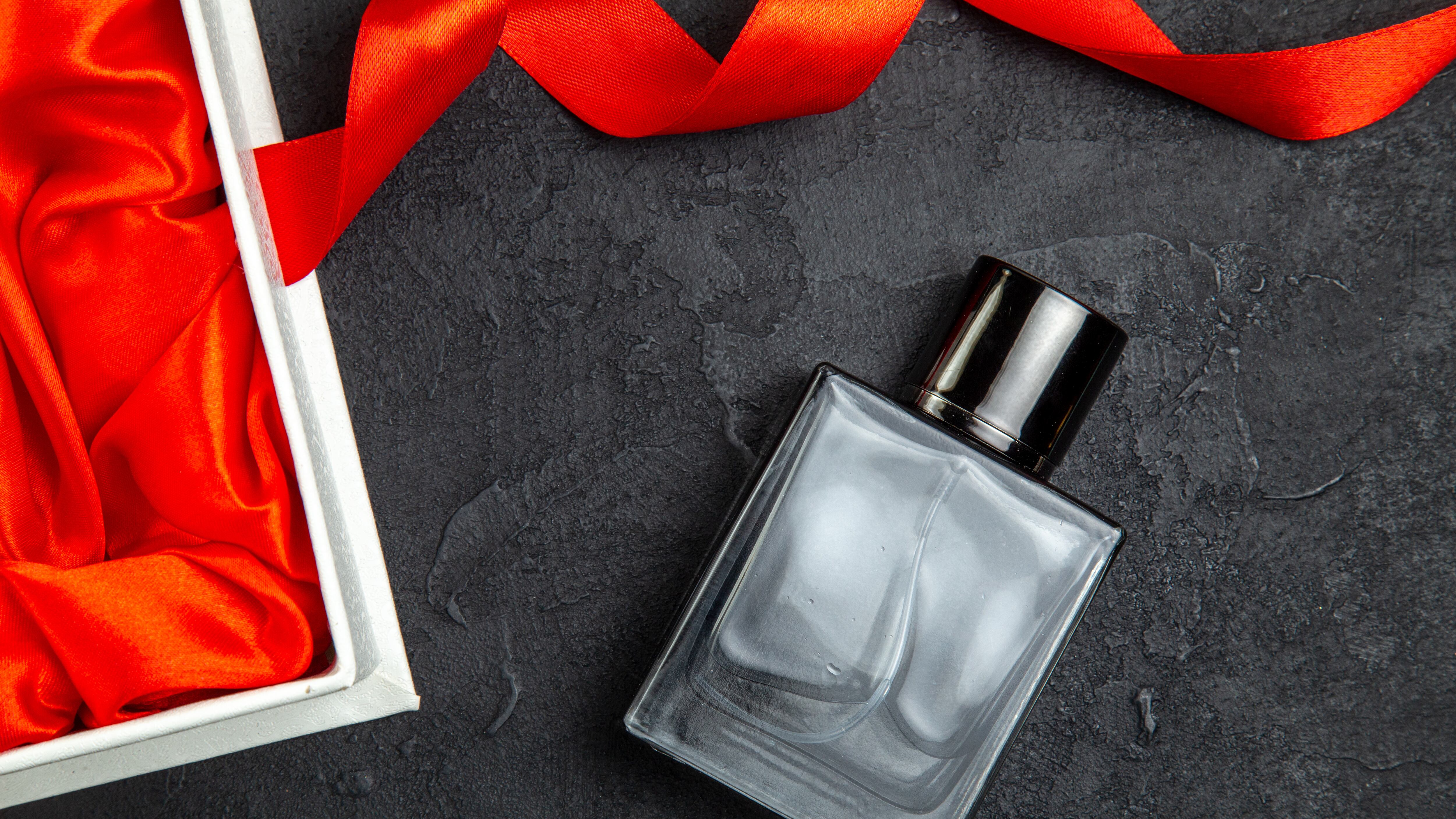 Frasco de perfume ao lado de embalagem de presente