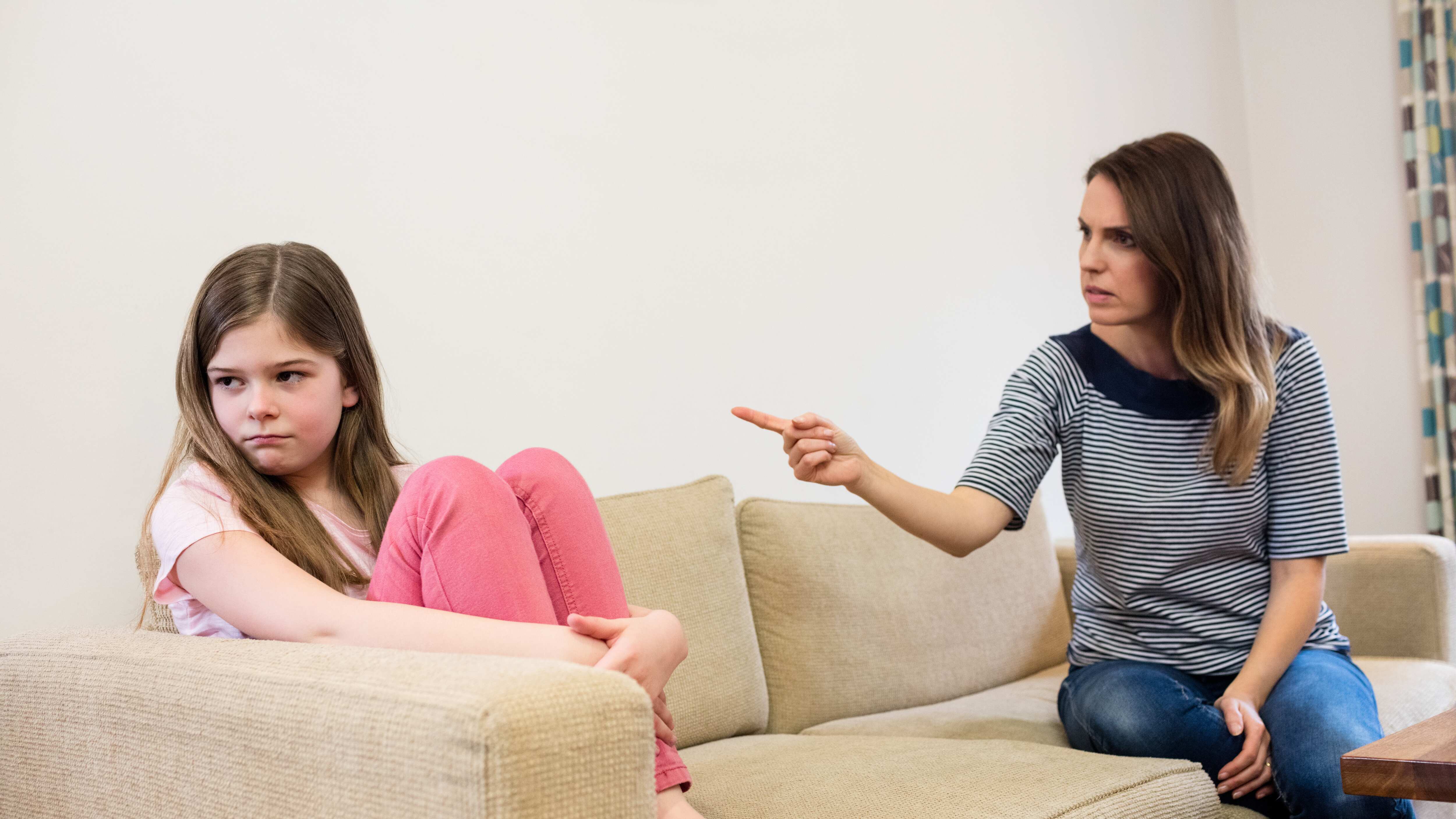 Daughter ignoring her mother after an argument in living room at home