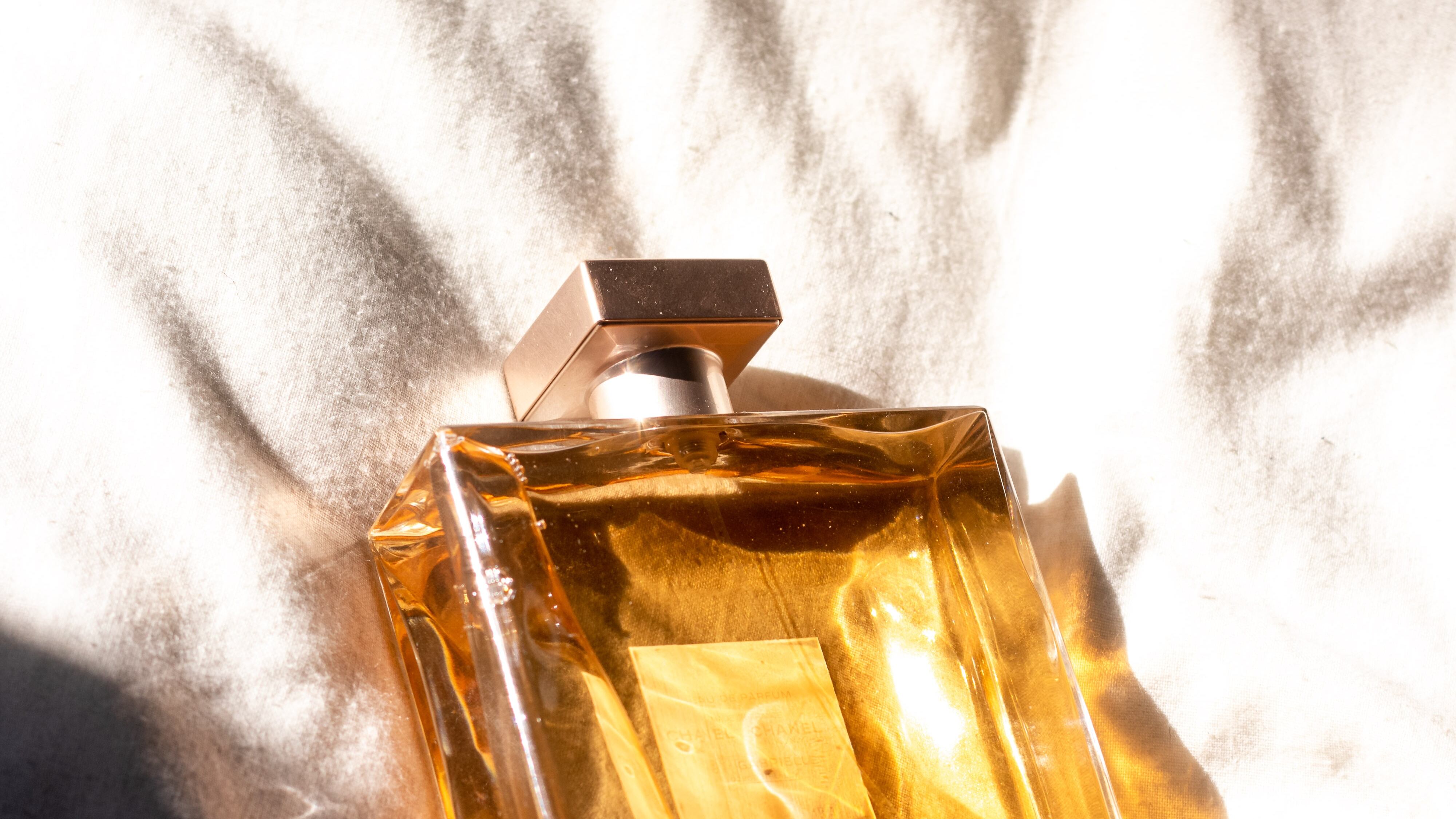 Frasco de perfume com líquido dourado