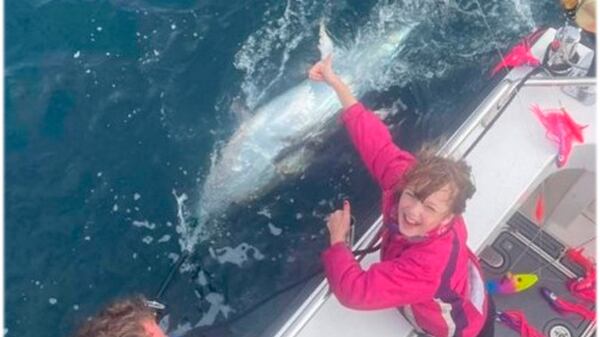 Menina pesca atum gigante