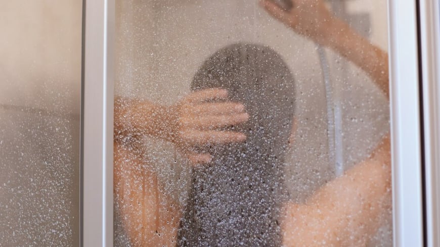 Disfrutando de una ducha. Vista posterior de la hermosa joven delgada sin camisa tomando ducha, lavarse el cabello en el baño, higiene, salud y belleza, tiro interior.