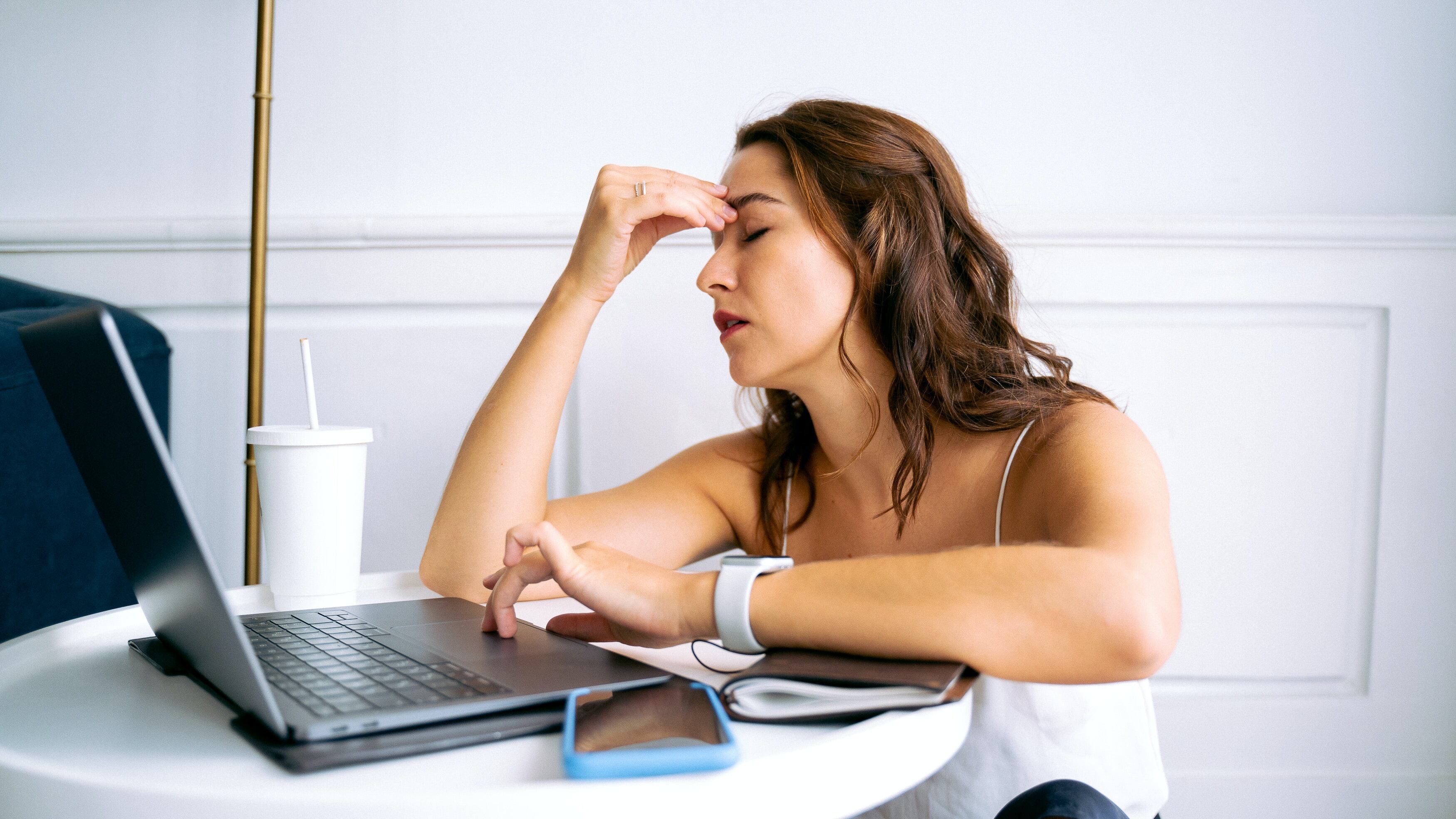 Mulher cansada mexendo no notebook