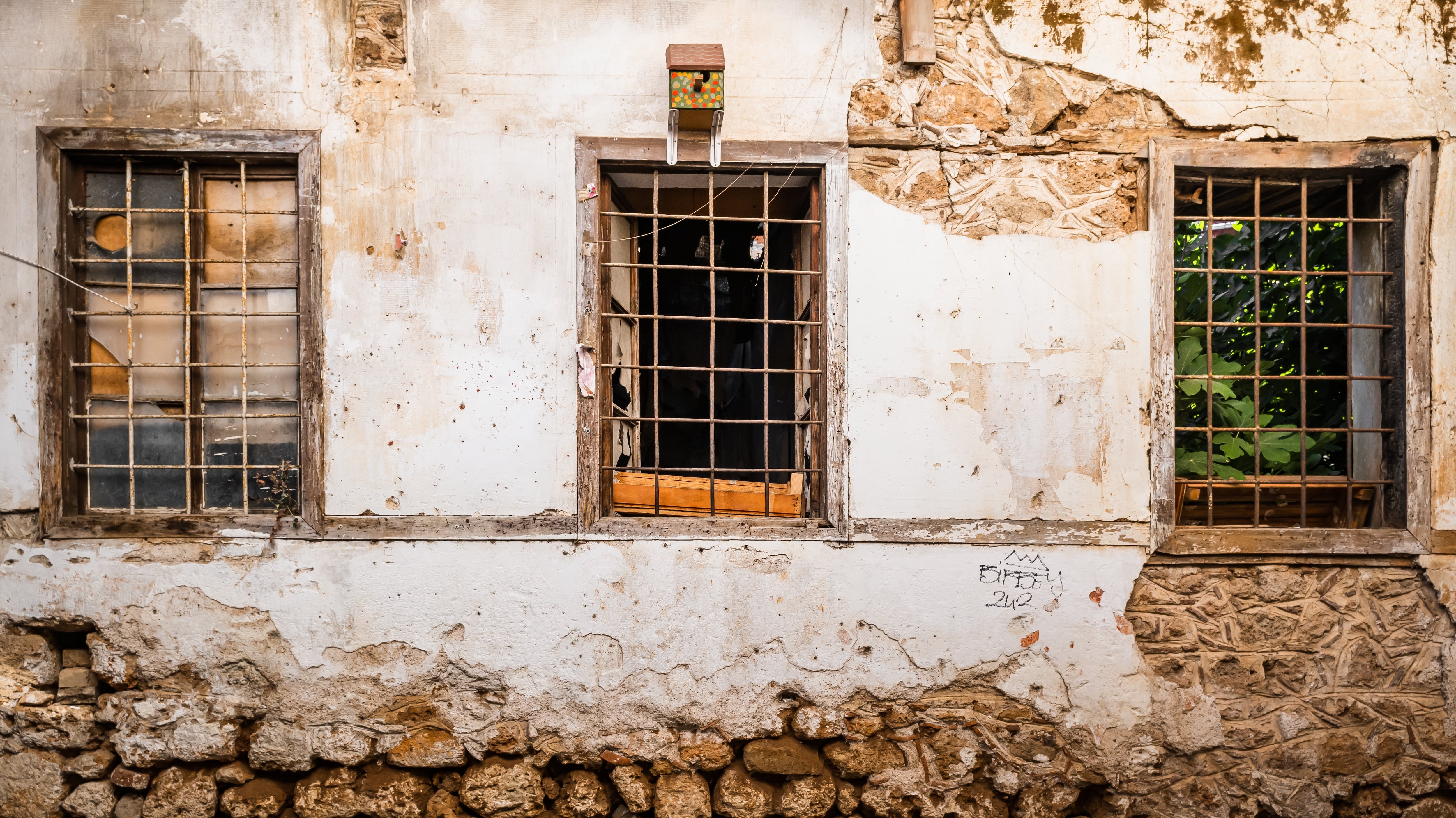 Parede velha com três janelas