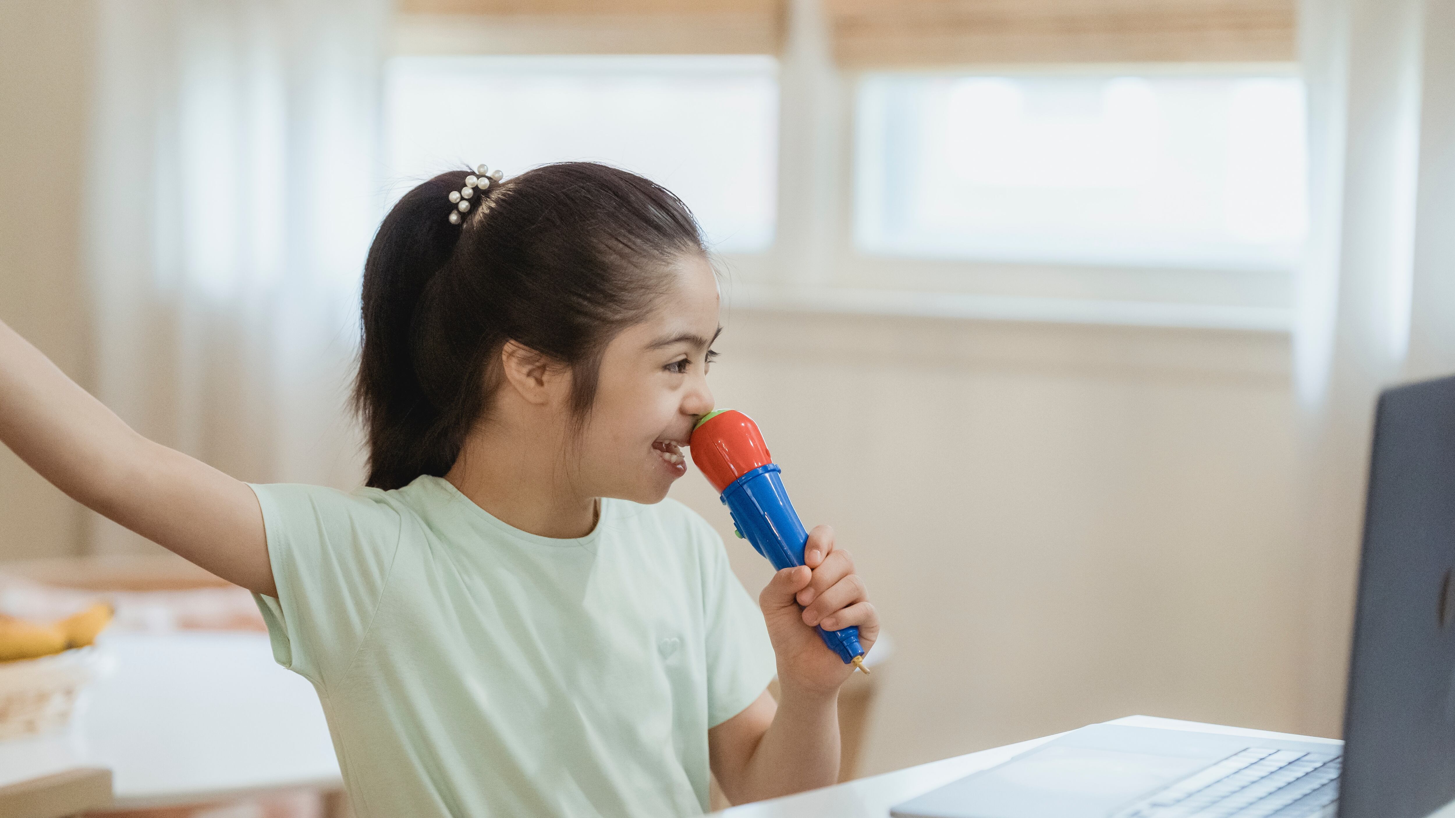 Criança cantando com microfone de brinquedo