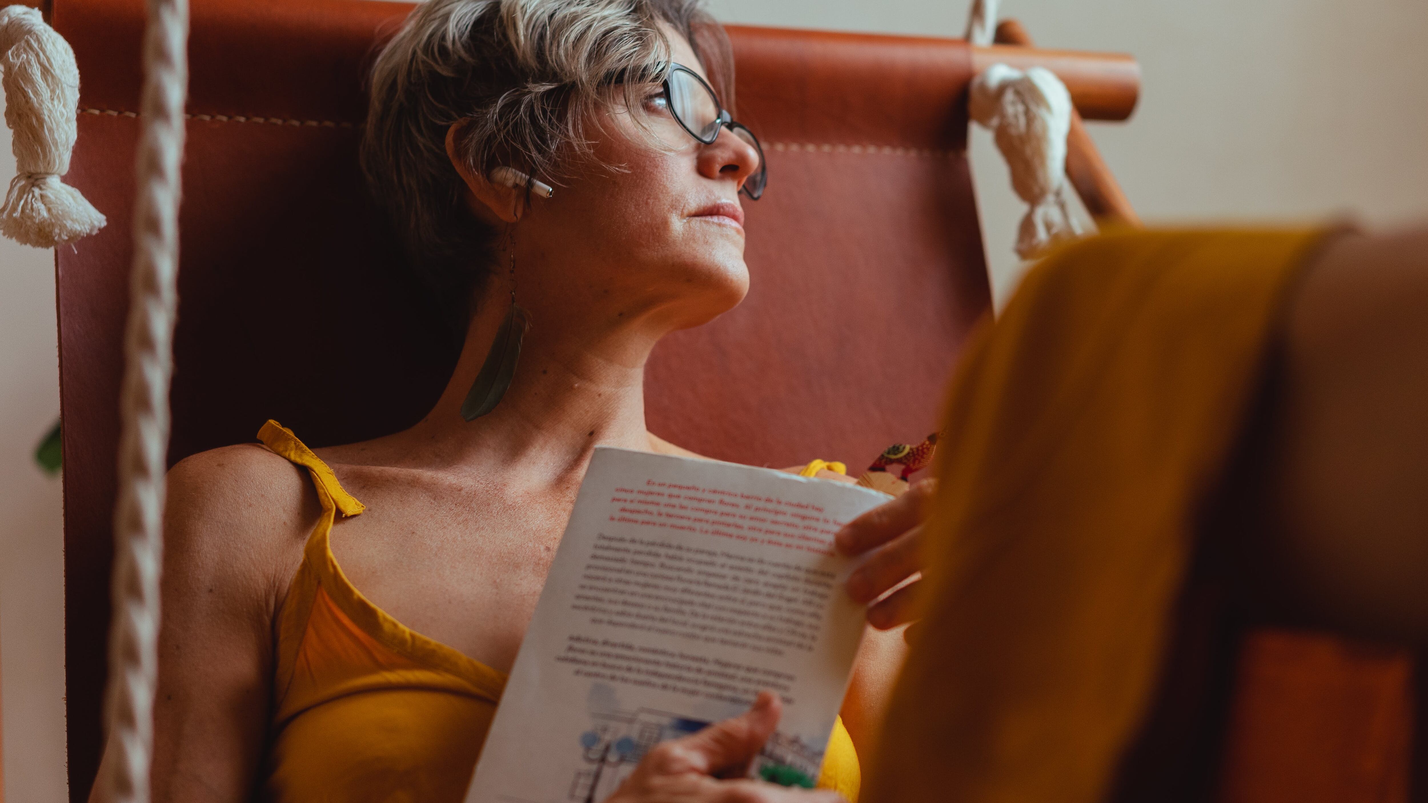 Mulher de óculos e cabelo curto lendo