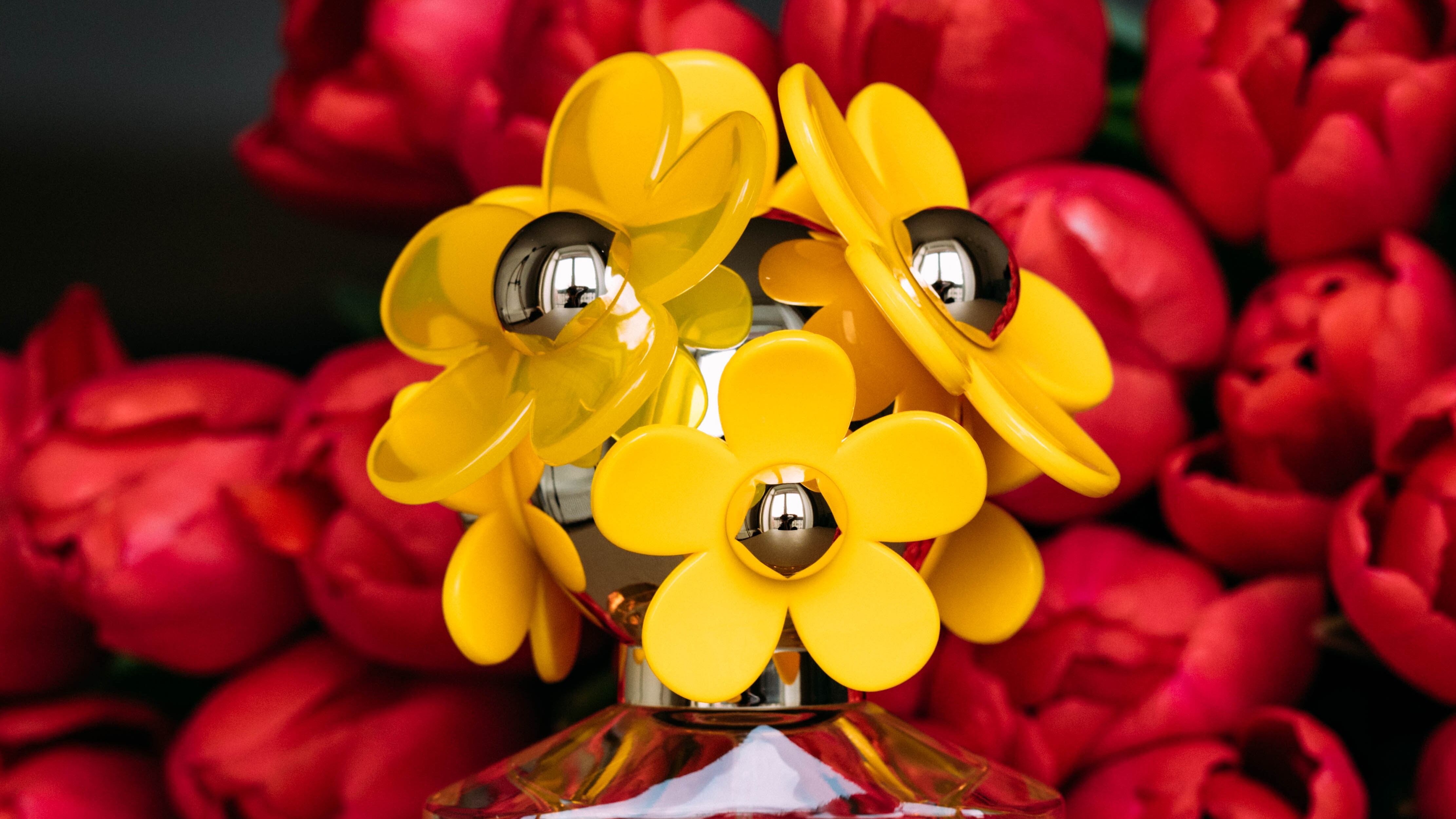 Perfume com rosas ao fundo