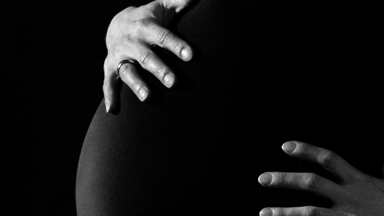 Silhueta feminina de vestido preto grávida