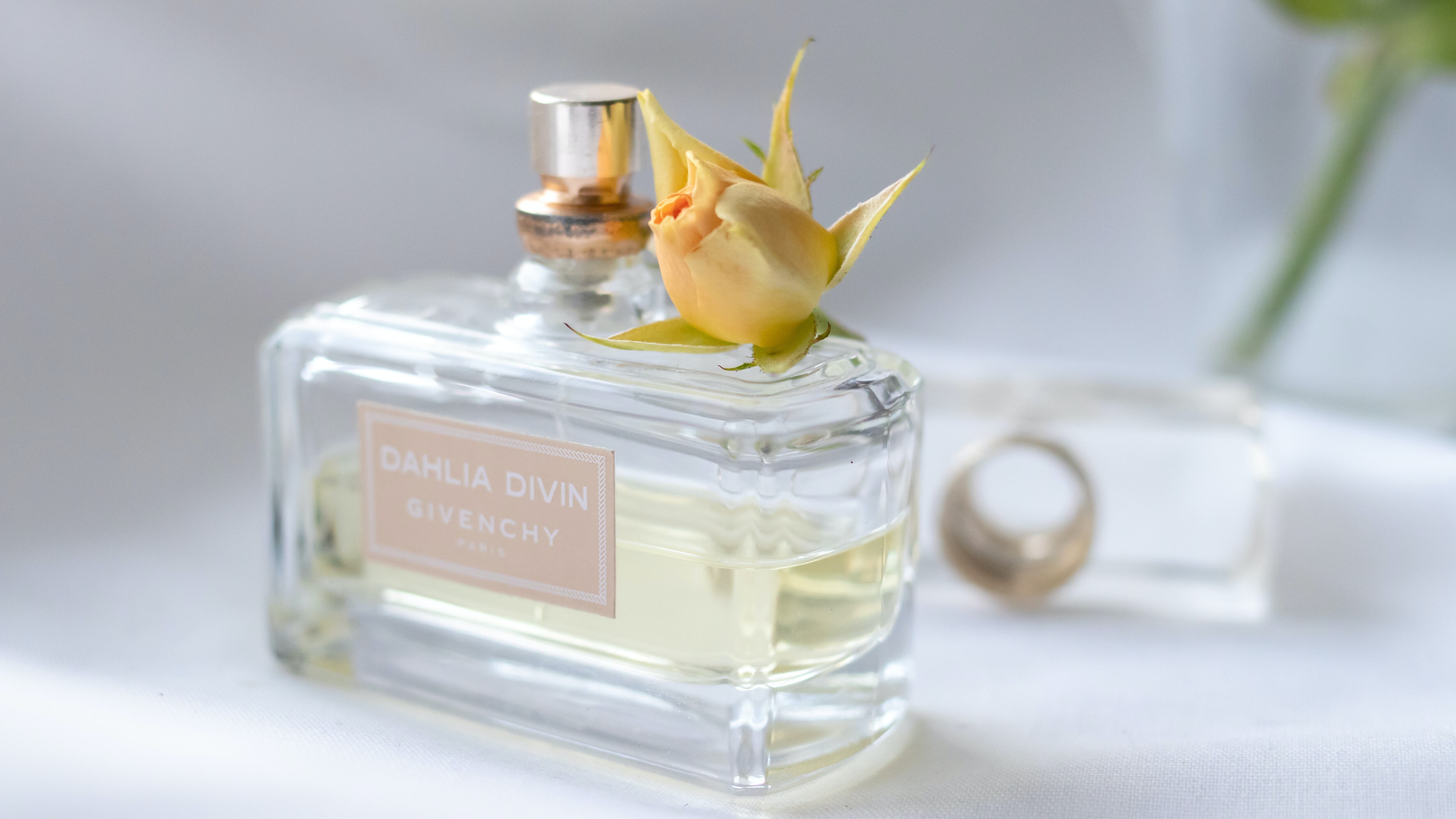 Frasco de perfume com flor em cima