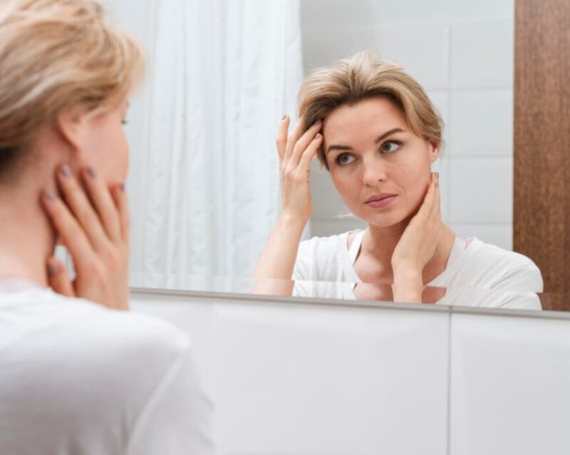 Mujer mirando en el espejo desde atrás