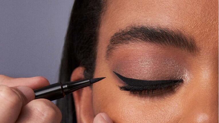 Foto de mulher aplicando delineador nos olhos