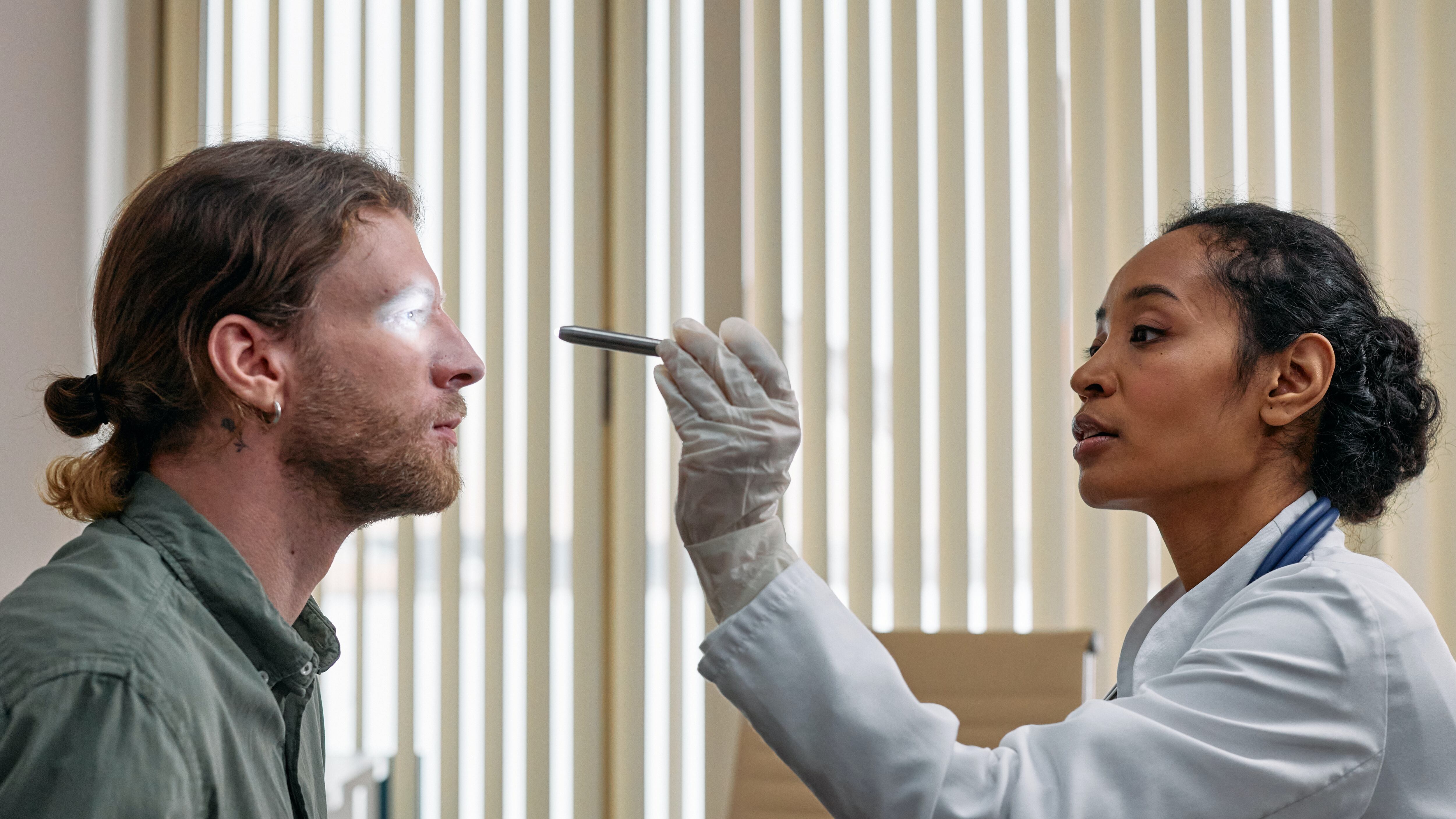 Médica oftalmologista analisando vistas de um paciente masculino