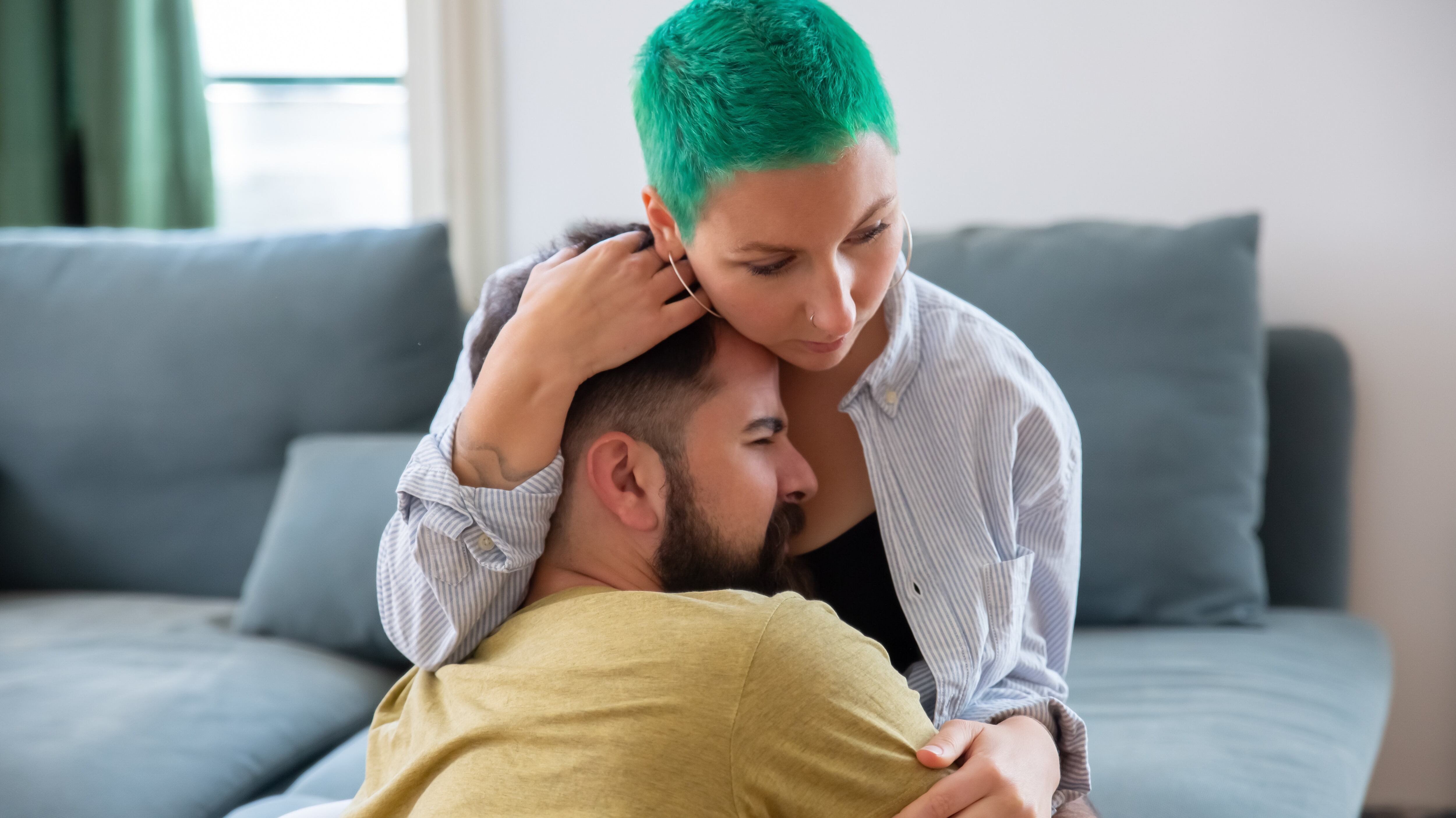 Mulher de cabelo verde consolando homem