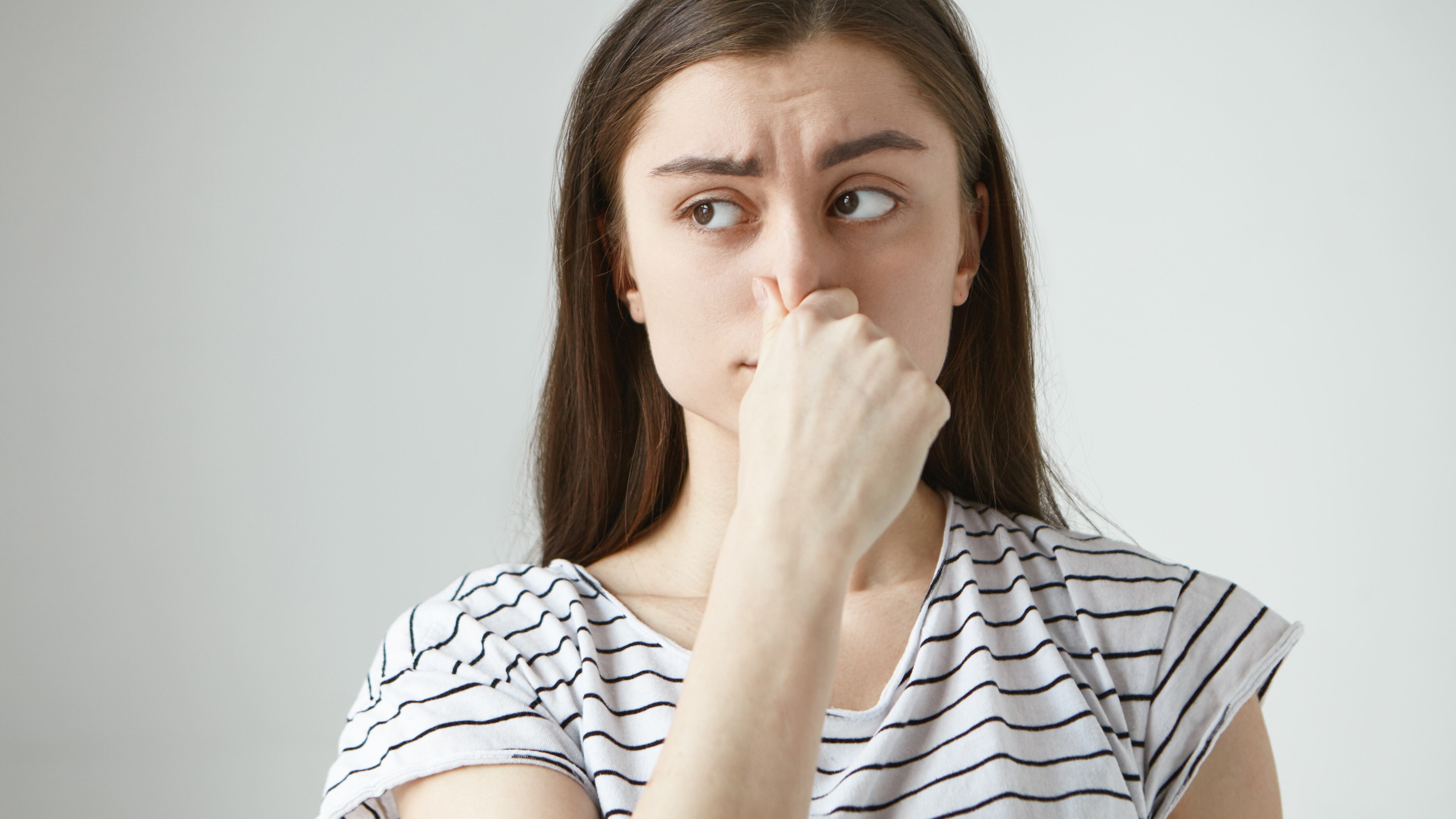 Mulher com mão no nariz