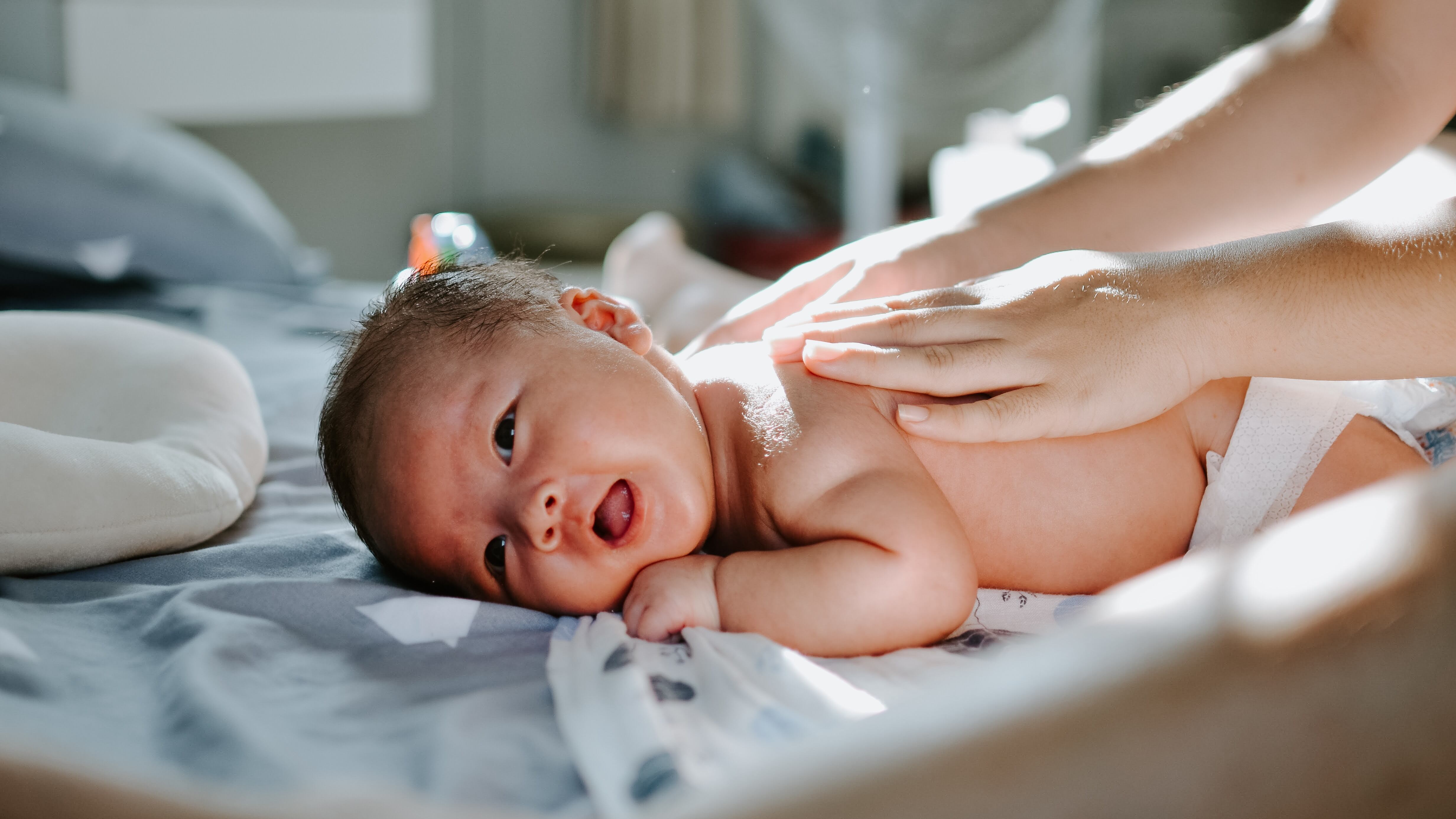 Mulher dando massagem nas costas do bebê