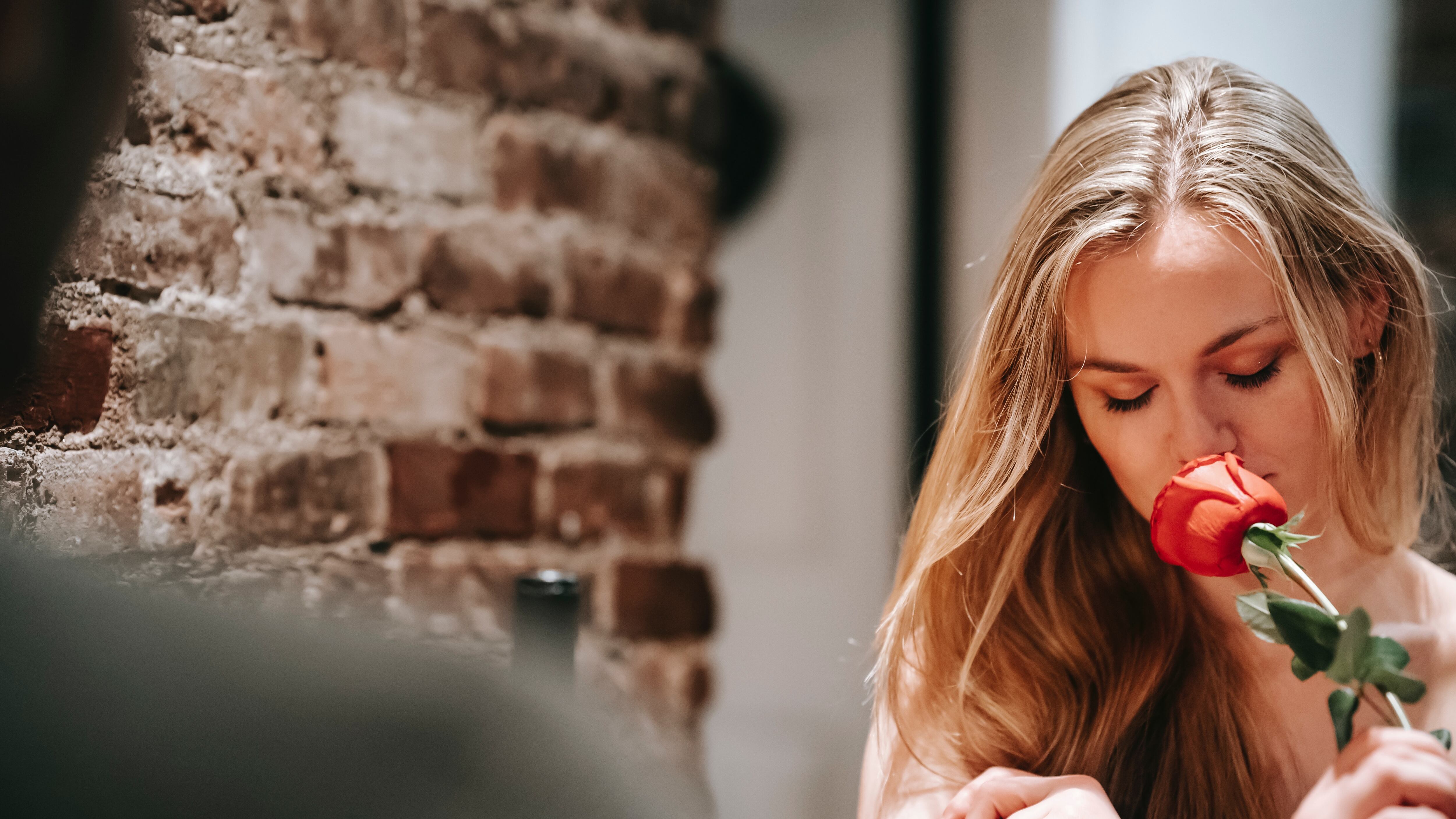 Mulher cheirando rosa