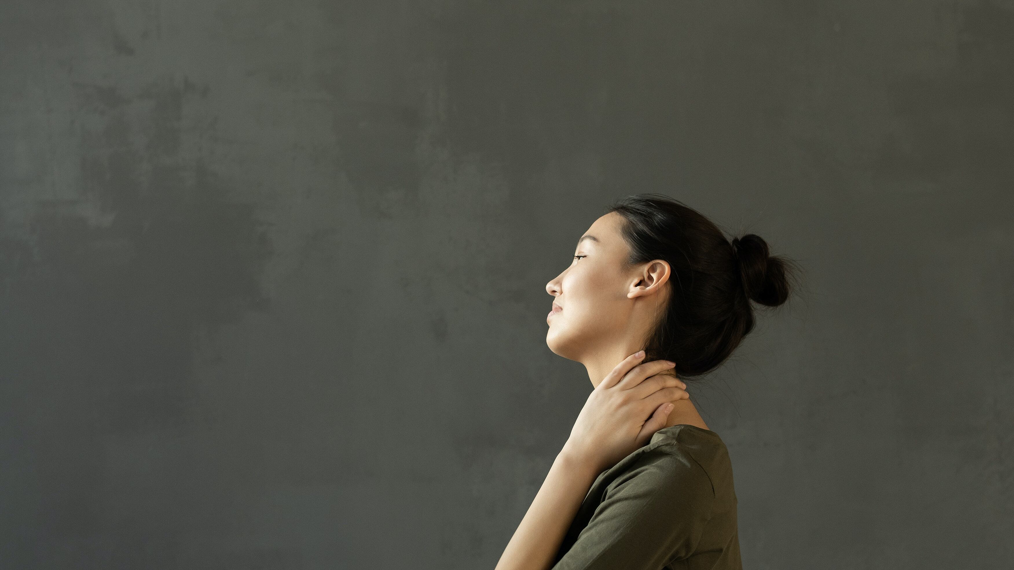 Mulher se levantando da cama com dor nas costas.