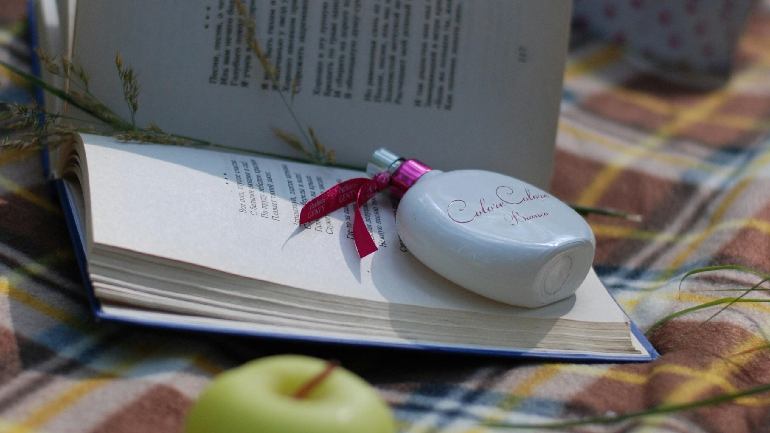 Frasco de perfume branco dentro de livro