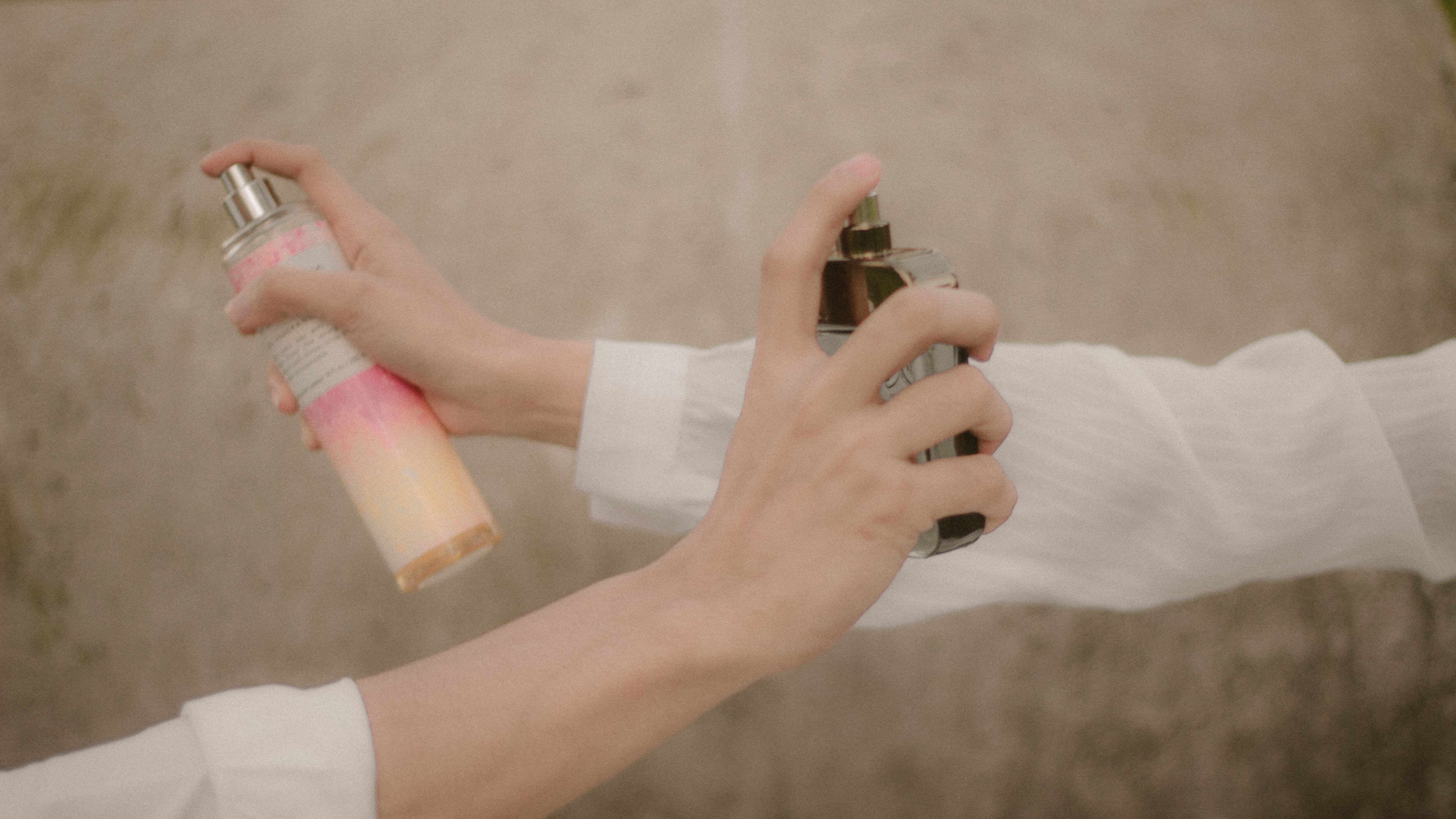 Mãos femininas segurando frascos de perfumes
