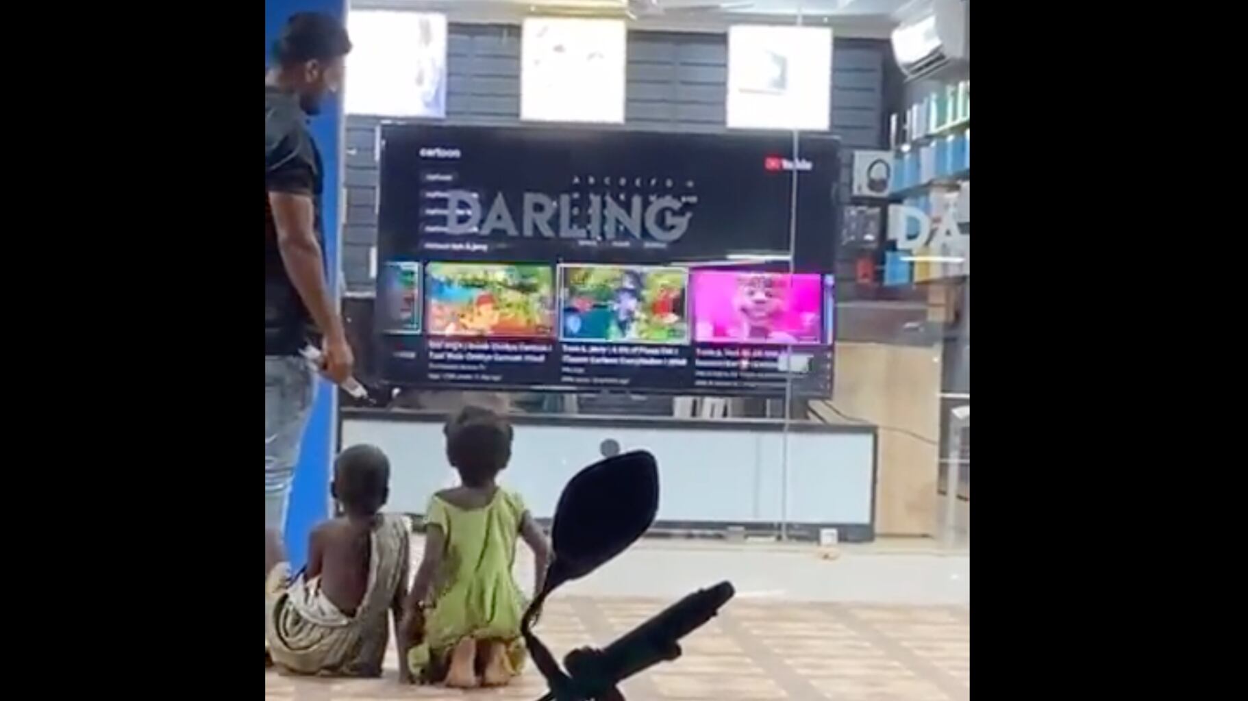 Vendedor deixar meninos escolherem programação de TV