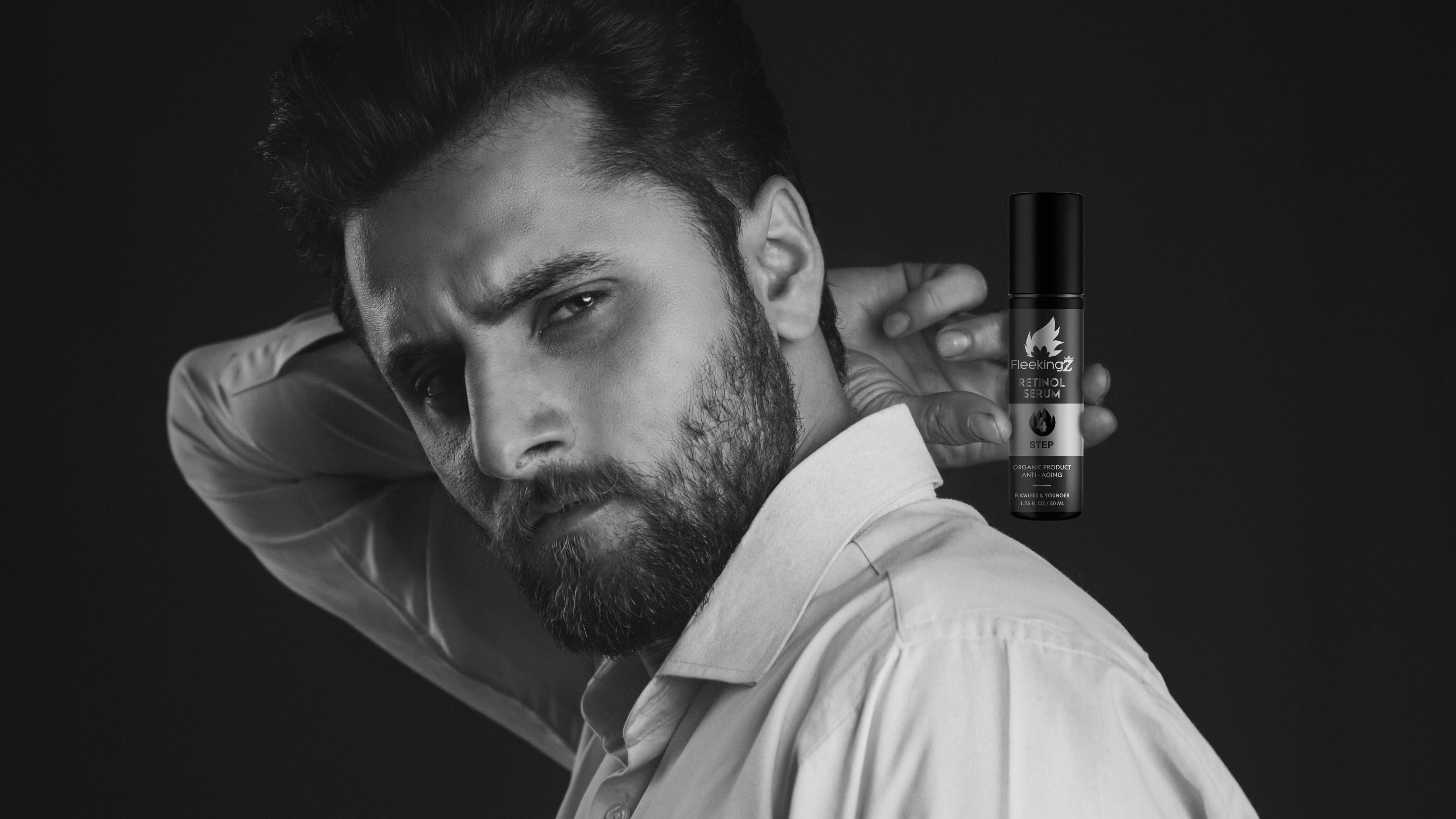 Imagem preto e branco de homem segurando frasco de perfume