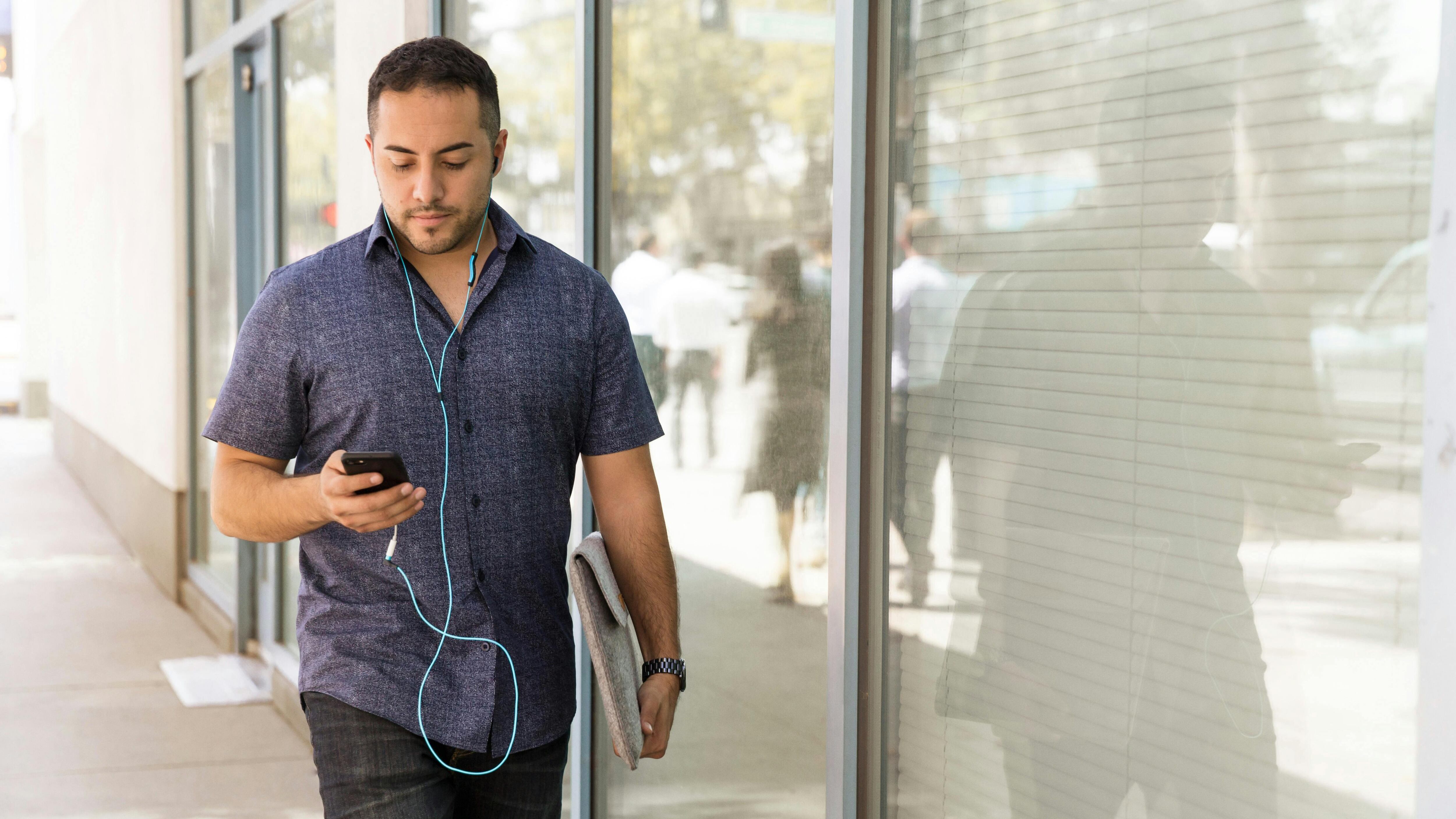 Homem andando e olhando para o celular