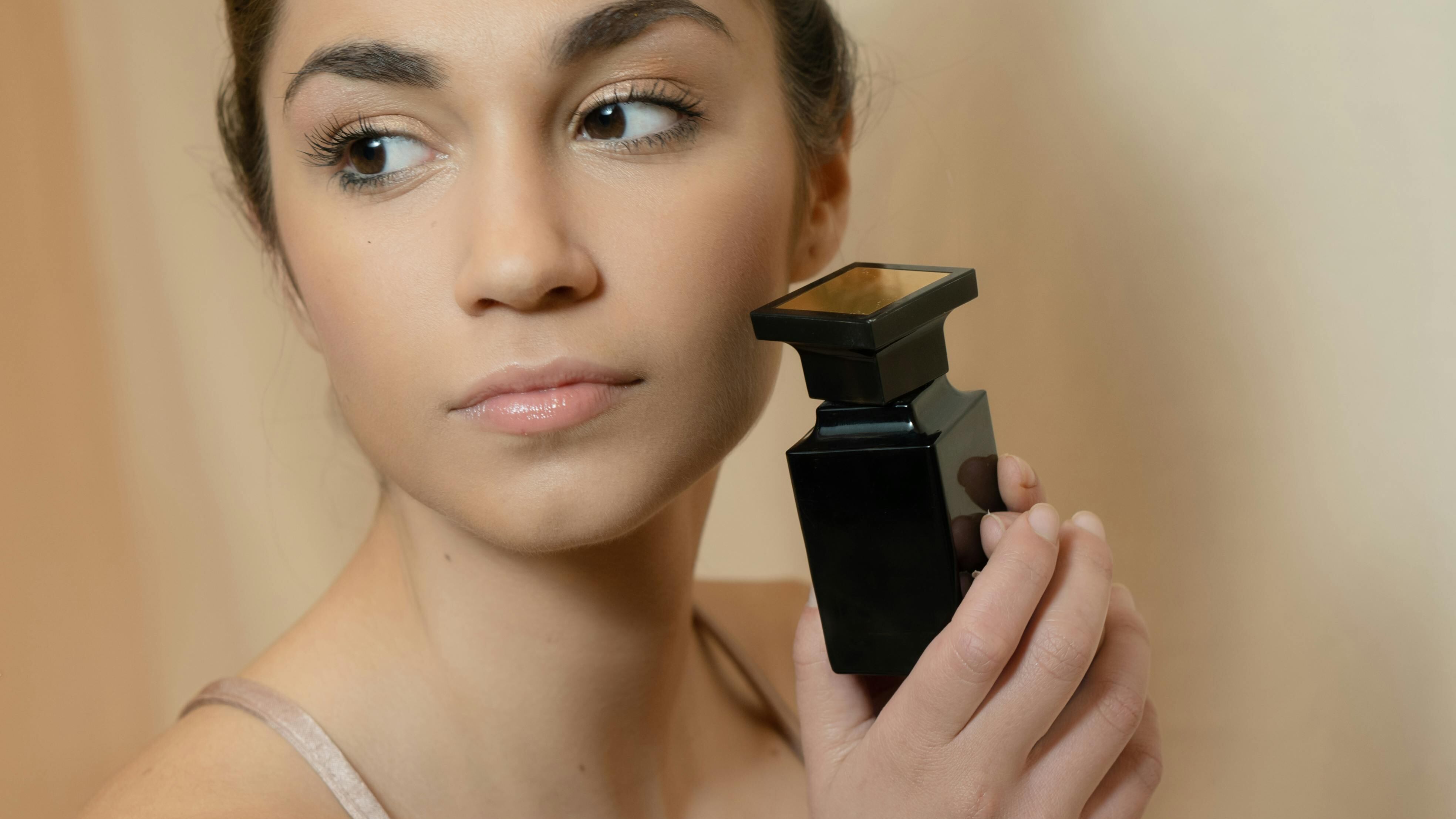 Mulher com frasco de perfume preto