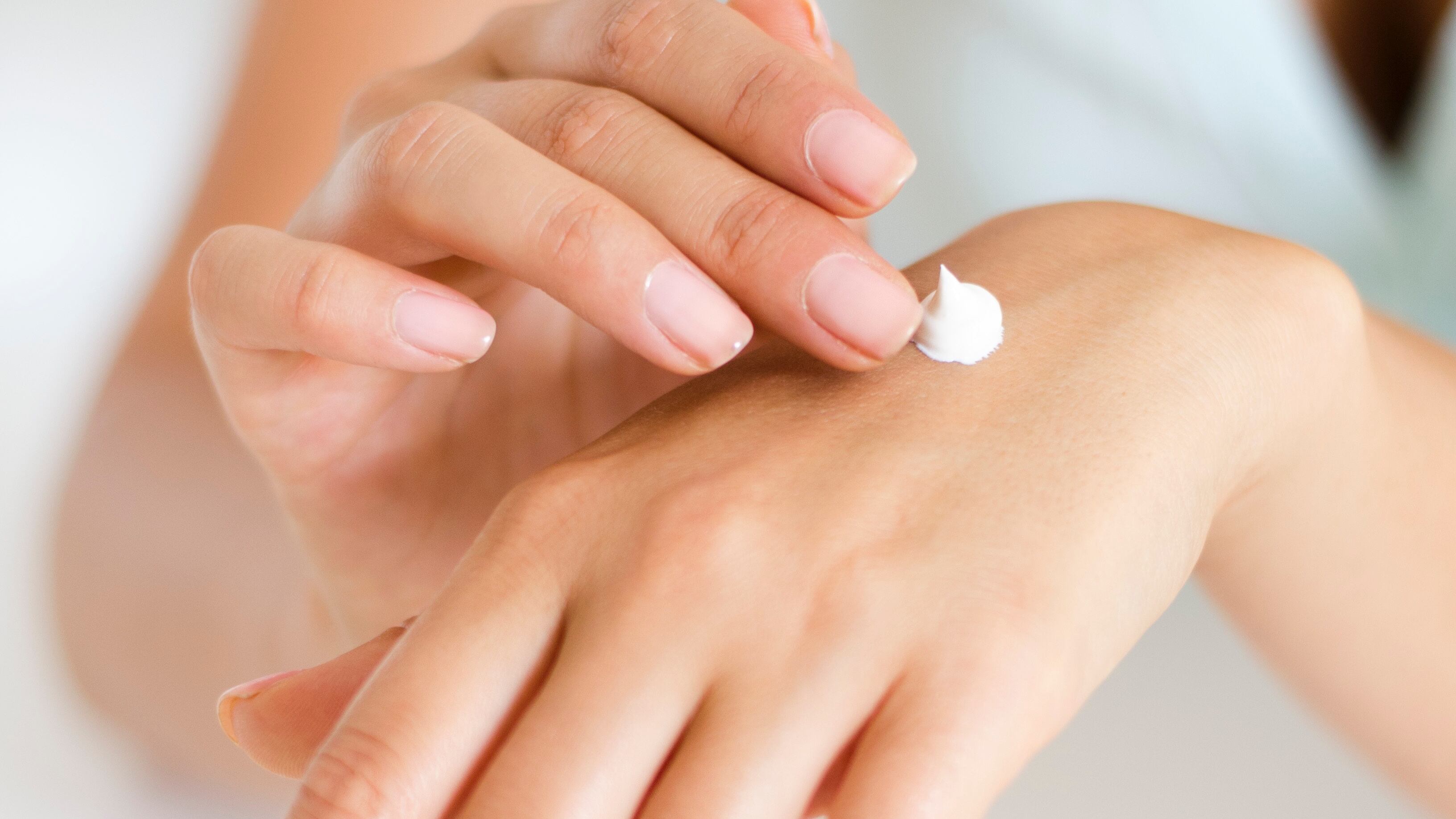 Mão feminina com creme na mão