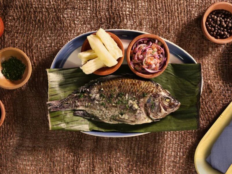 Pescado envuelto en hojas de bijao, acompañado de yuca o plátano asado.