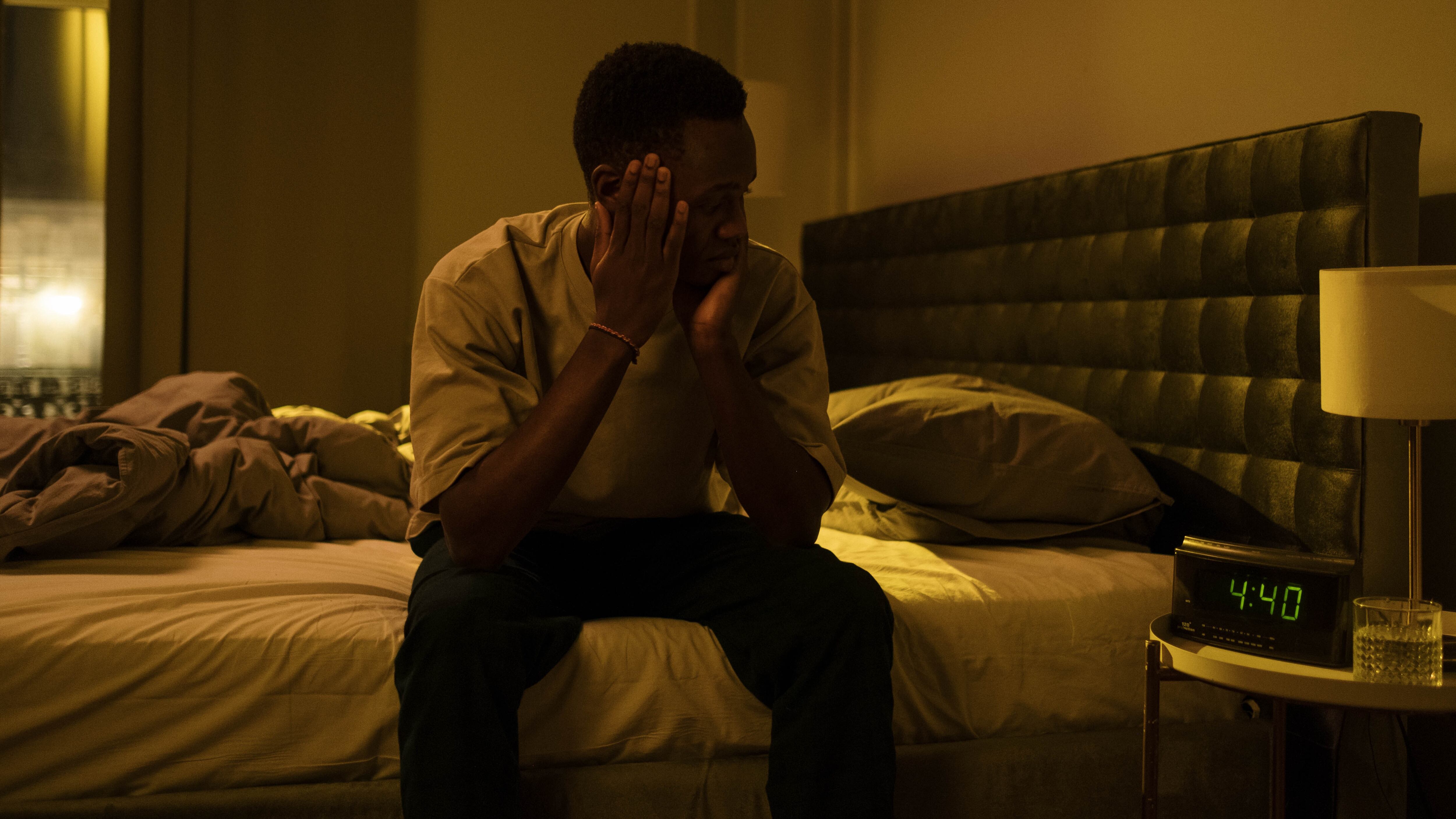 Homem com insônia olhando para relógio