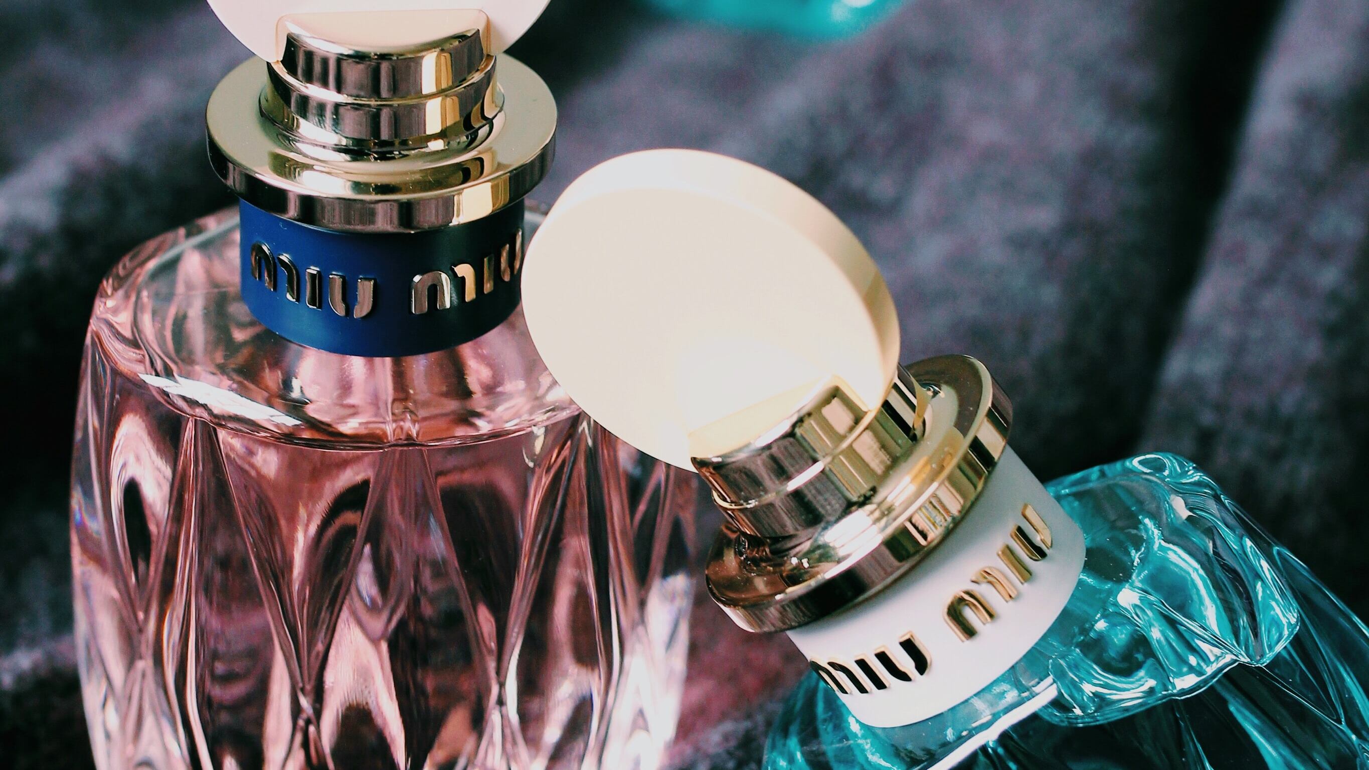 Dois frascos de perfumes azuis e um rosa