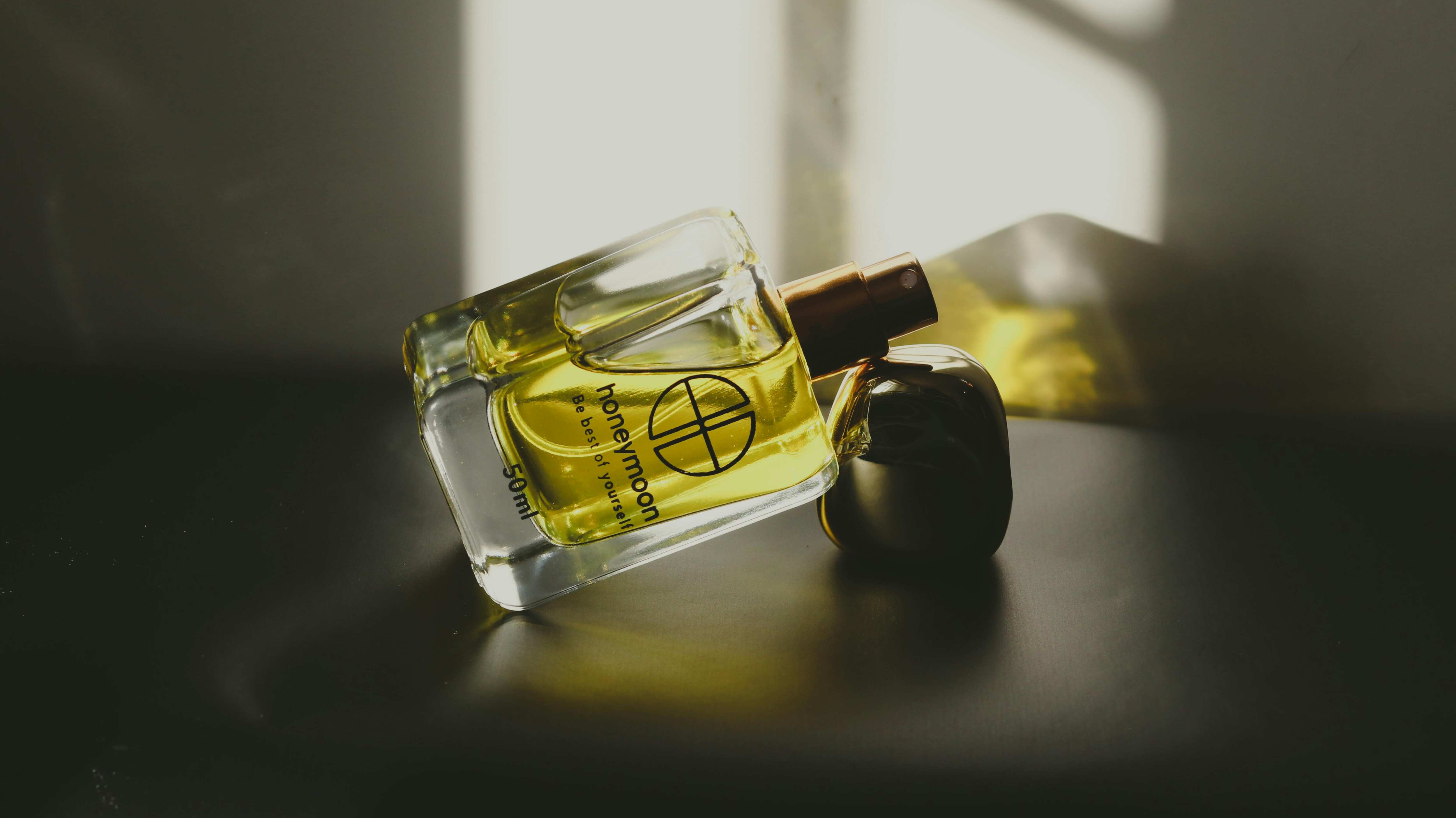 Frasco de perfume deitado com líquido amarelo