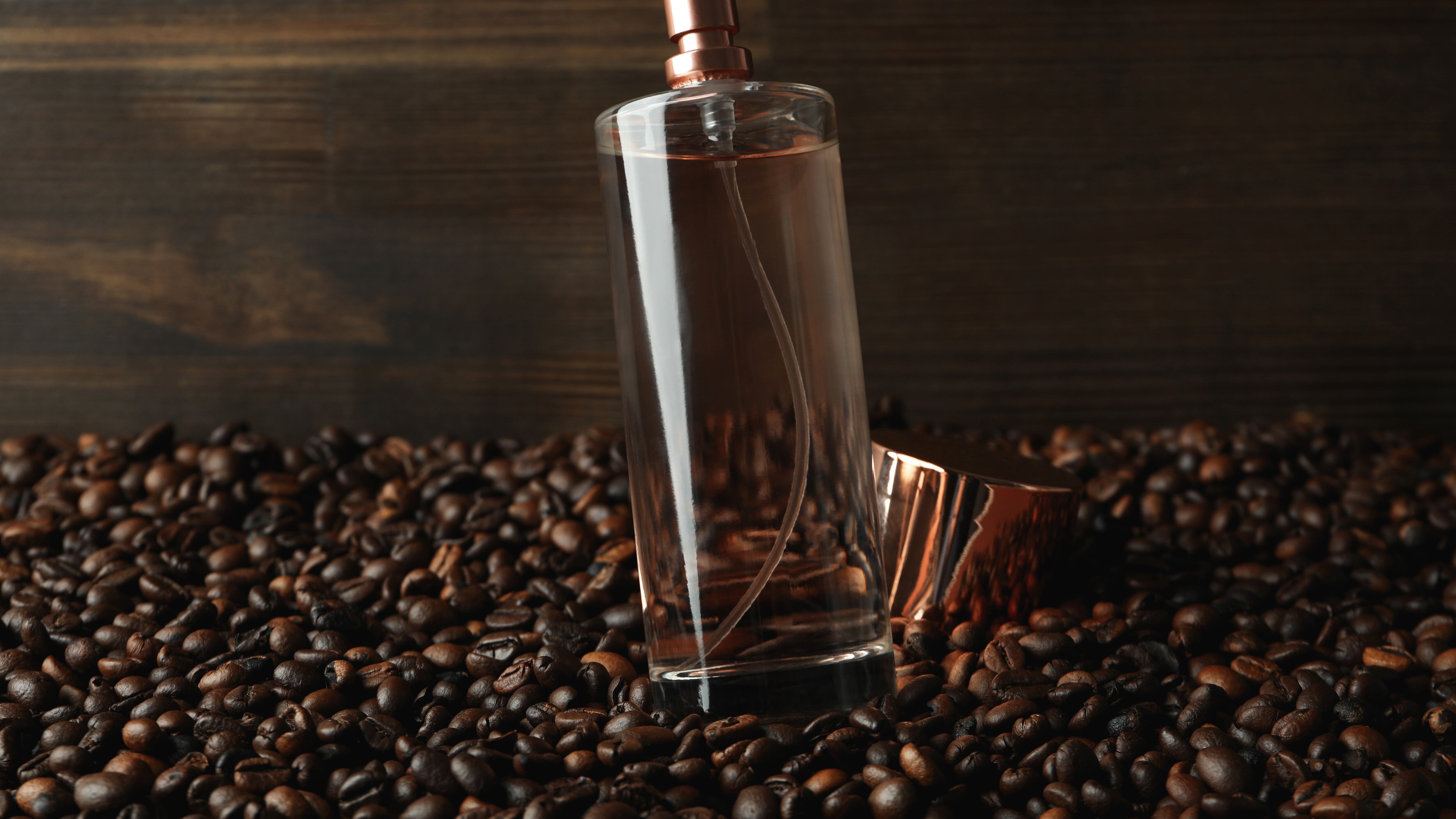 Frasco de perfume ao lado de grãos de café