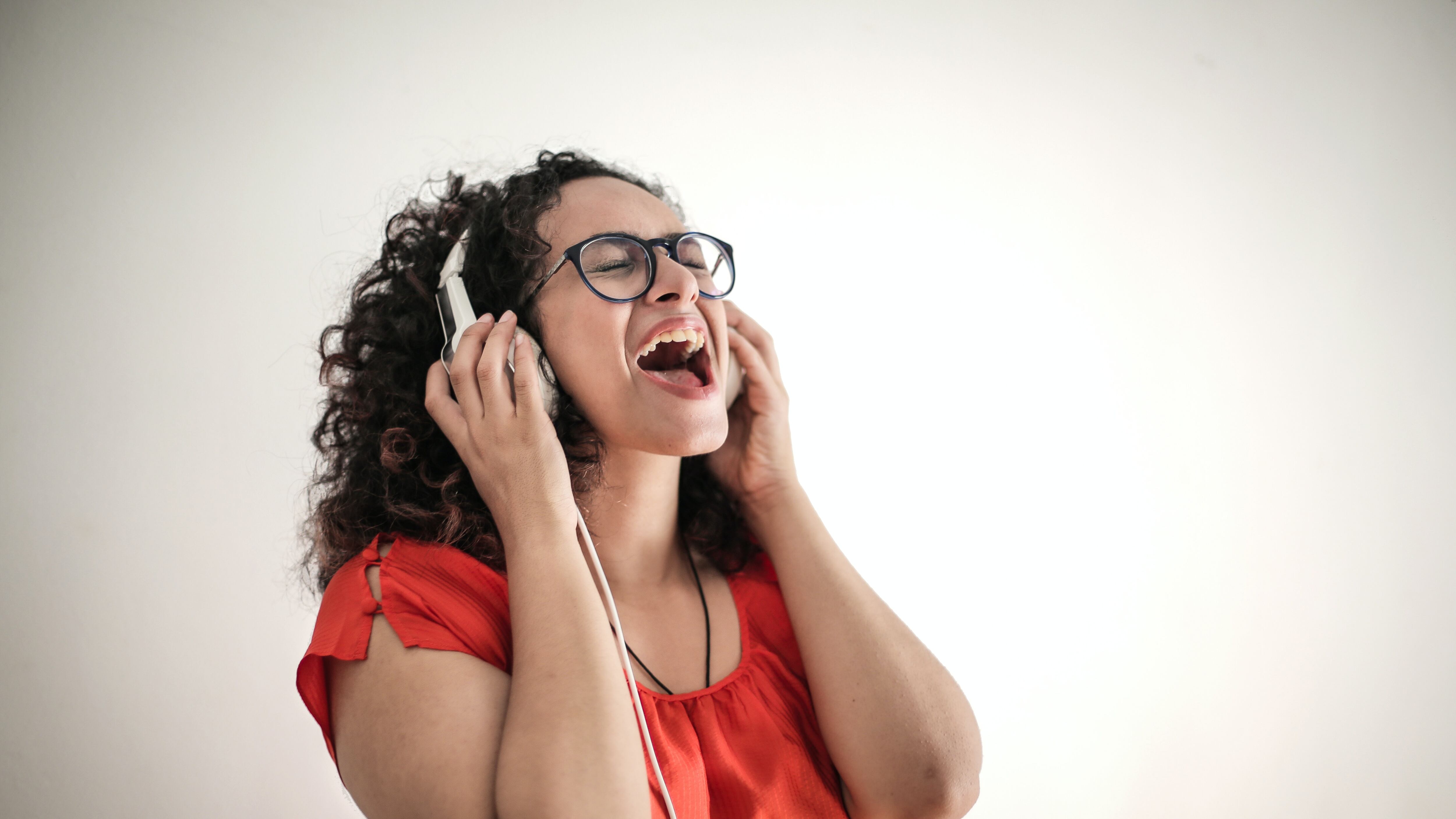 Mulher escutando música com headset e cantando