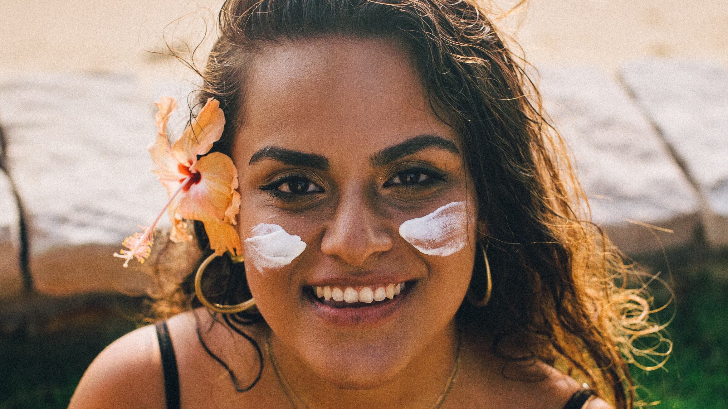 Mulher com protetor solar na bochecha