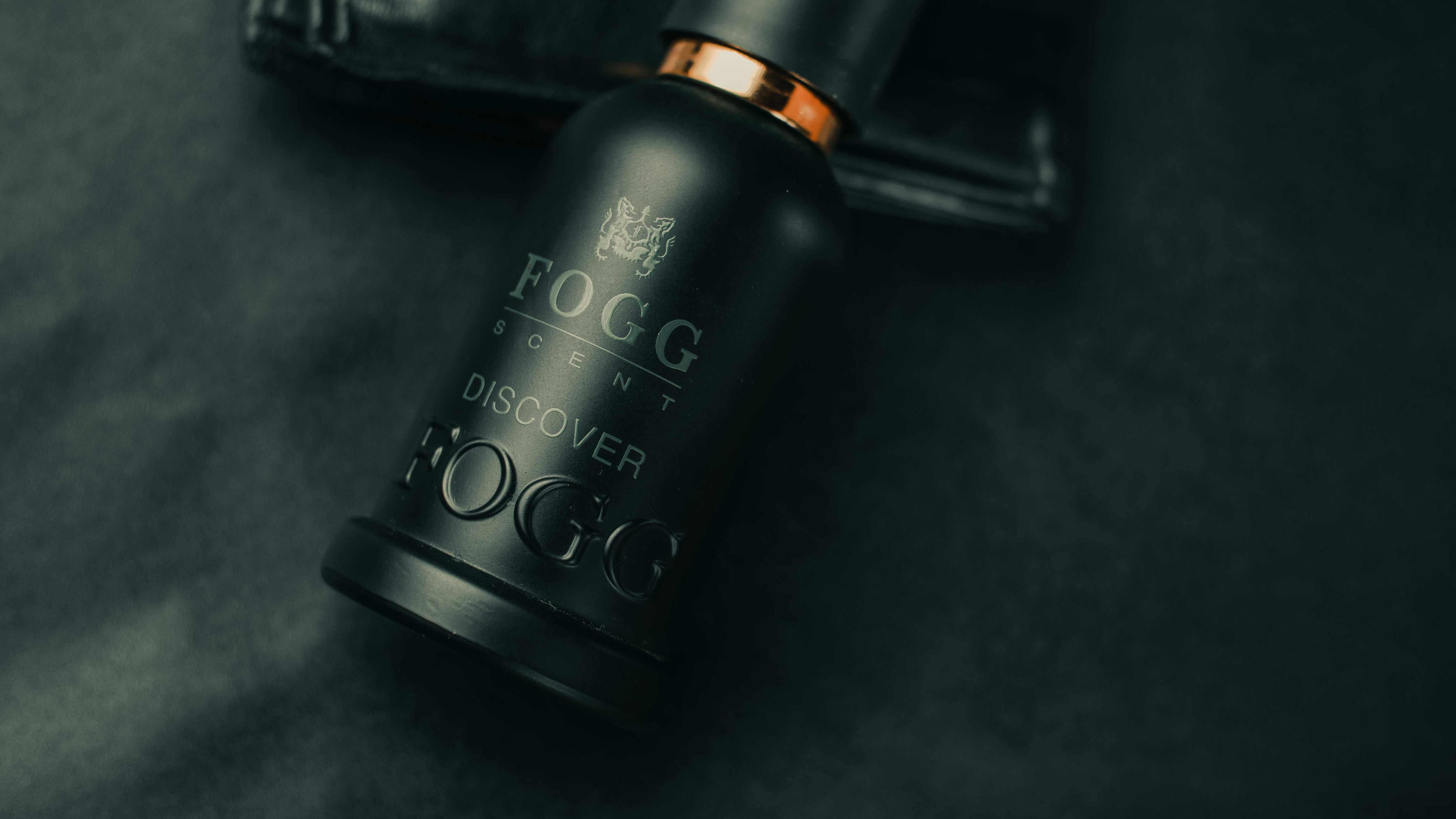 Perfume preto ao lado de carteira