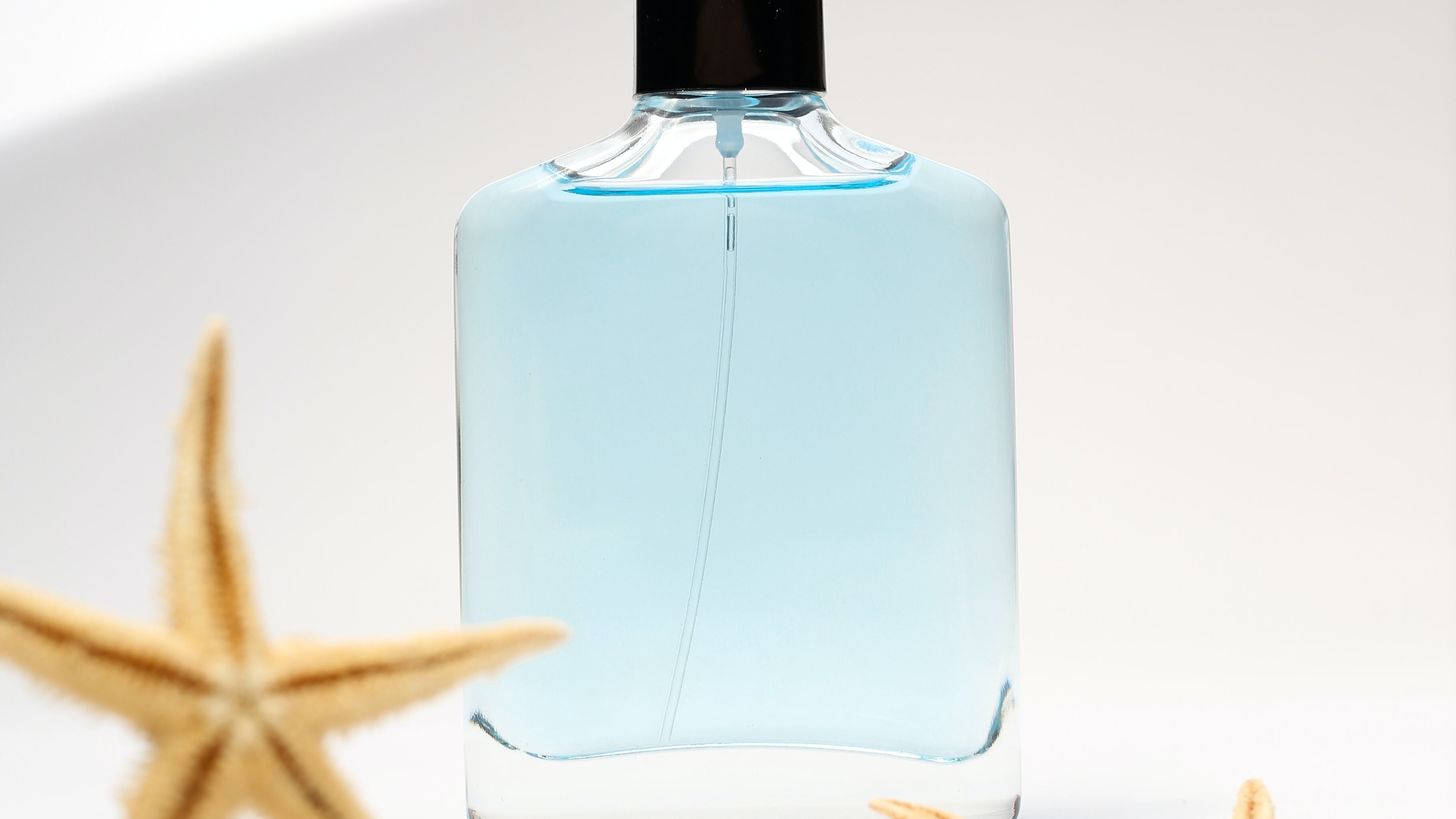 Perfume aquático ao lado de uma estrela do mar