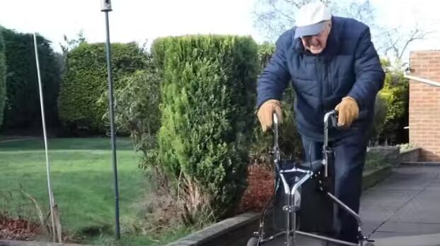 Com 100 anos, o cabo Jones caminha pelo jardim todos os dias. Com o desafio do andador, ele já conseguiu arrecadar R$ 270 mil reais para ajudar pessoas com doença neuronal motora. - Foto: reprodução/SWNS