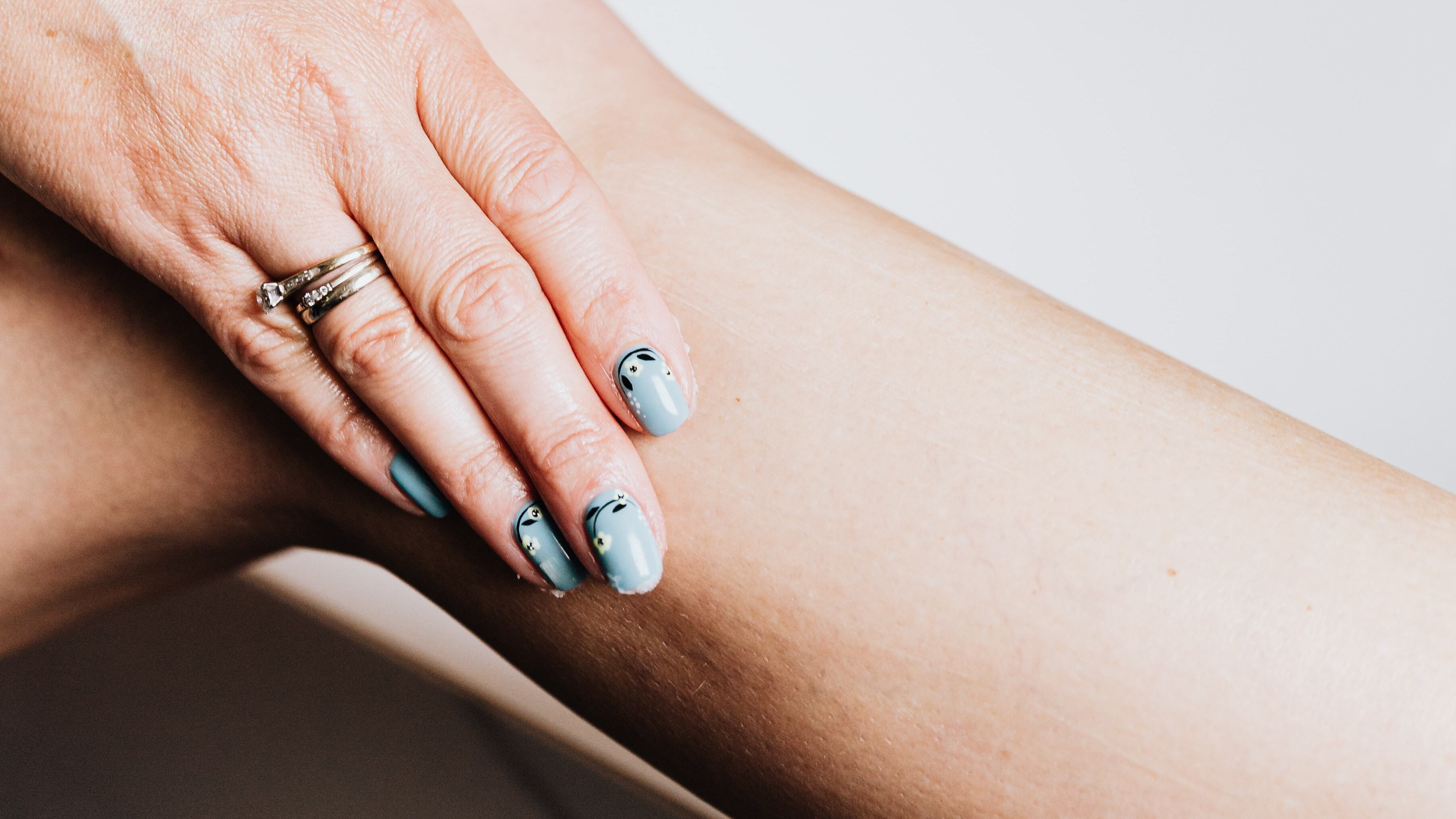 Mulher passando hidratante na perna