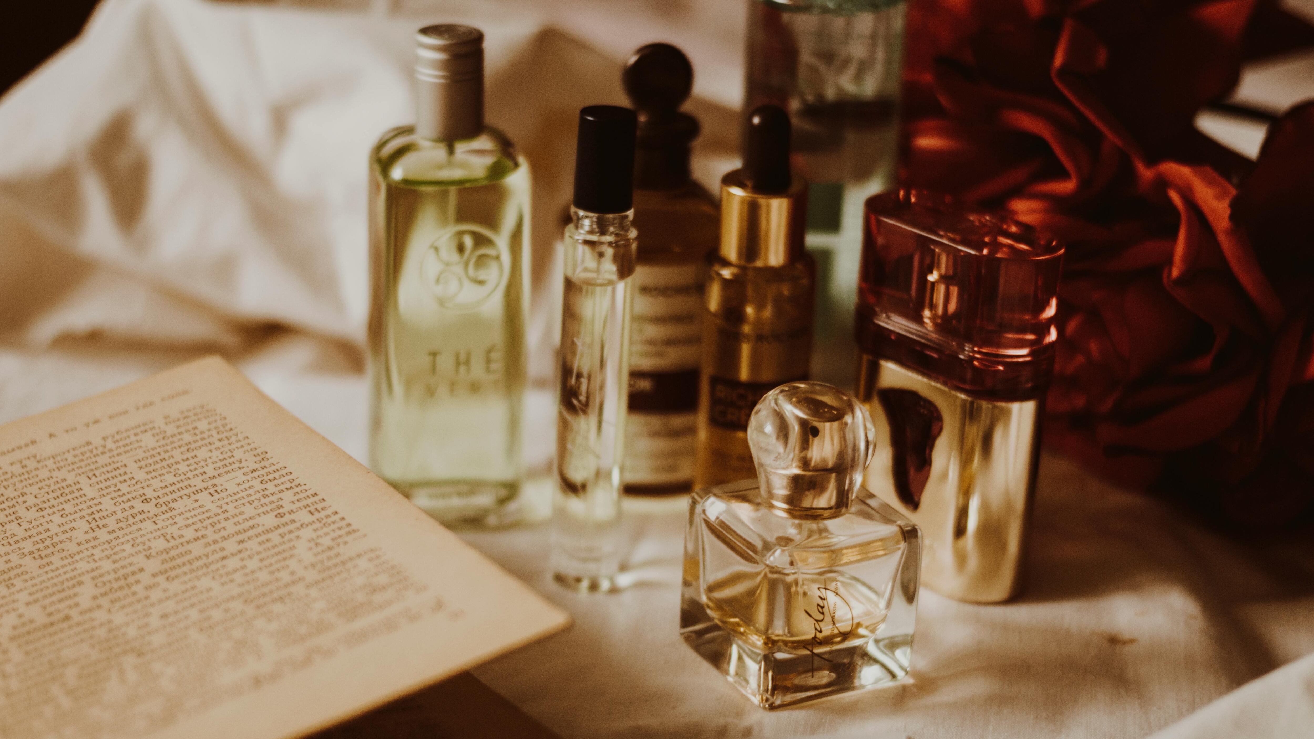 Frascos de perfume ao lado de livro com página antiga