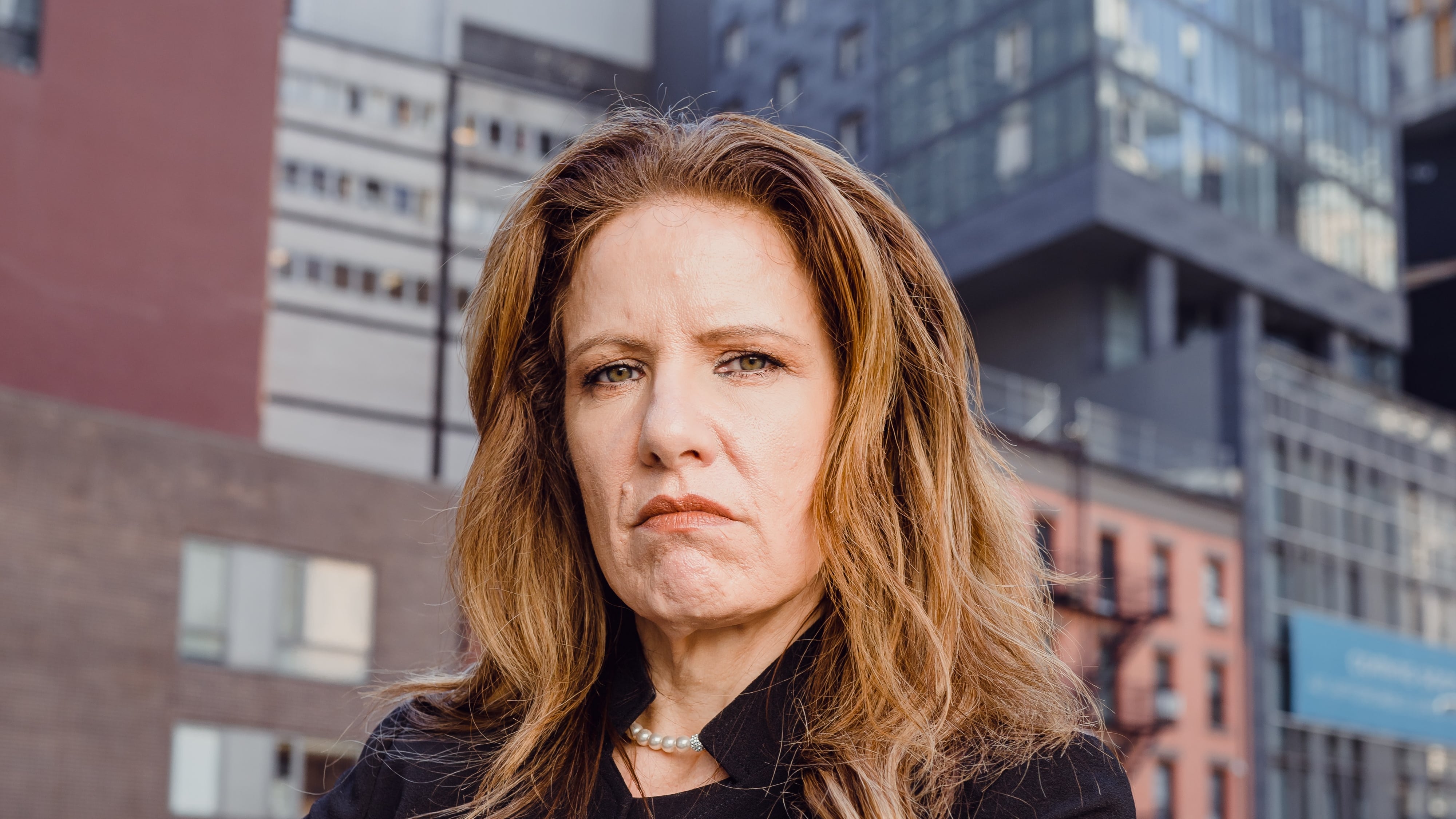 Mulher ruiva de terno com os braços cruzados