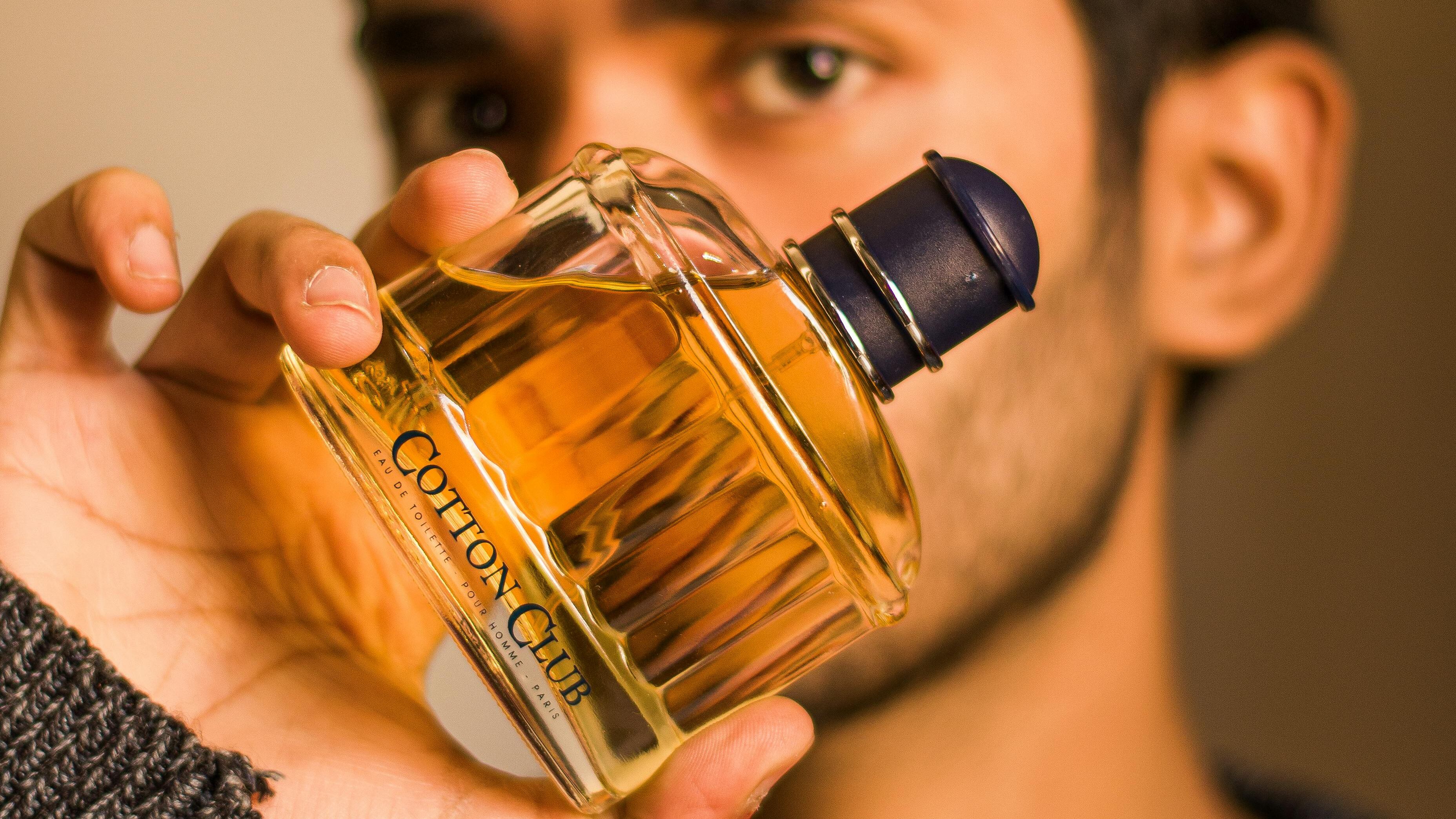 Homem segurando frasco de perfume