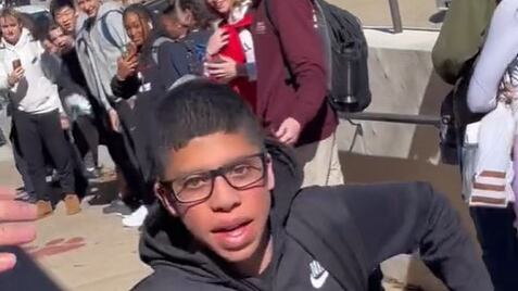 Jovem corre na escola enquanto outros estudantes o apoiam