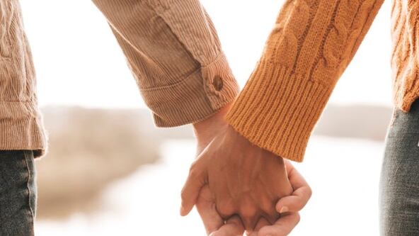 Vista posterior pareja tomados de la mano