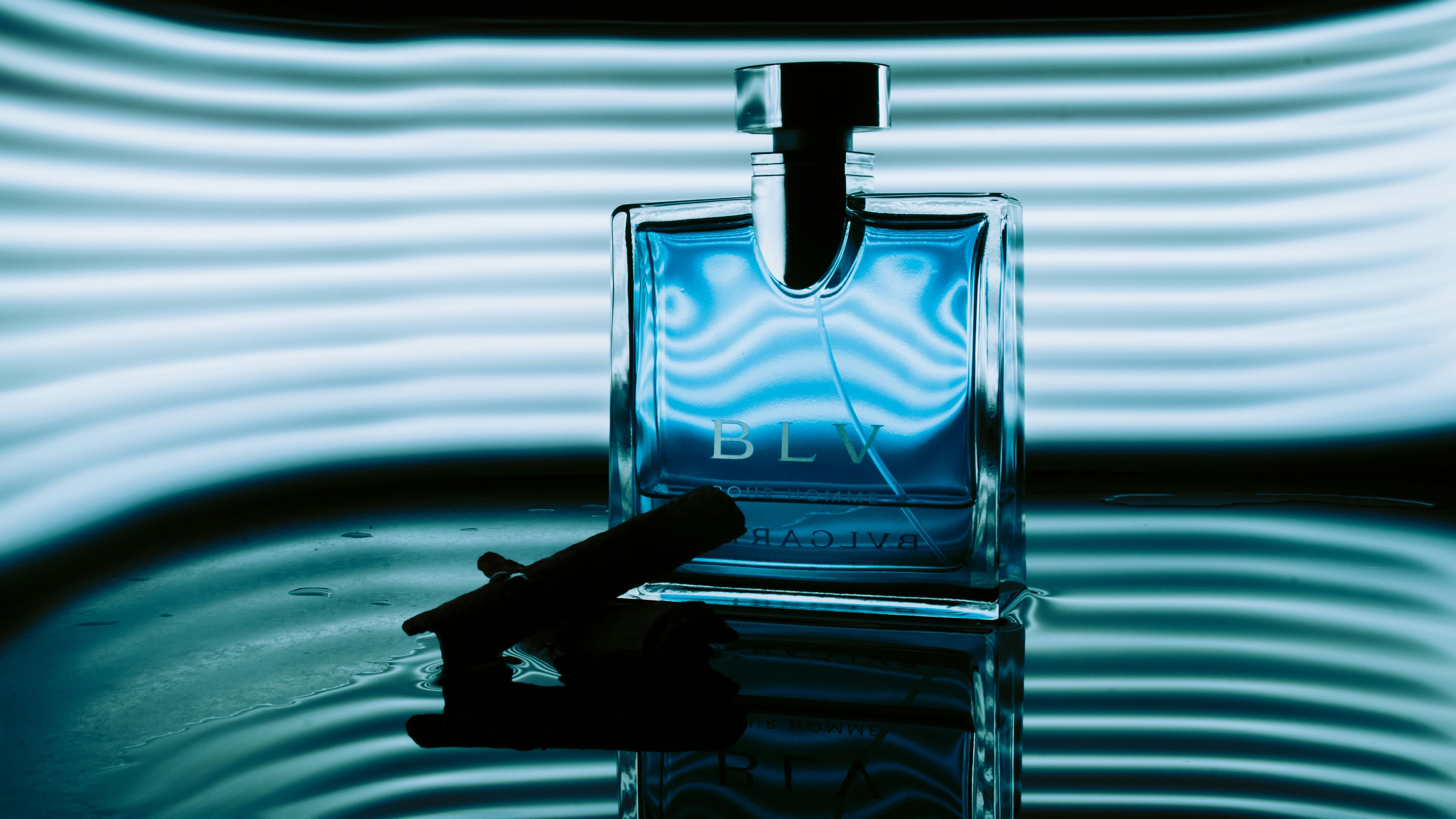 Frasco de perfume com inscrições BLV azul e fundo azul