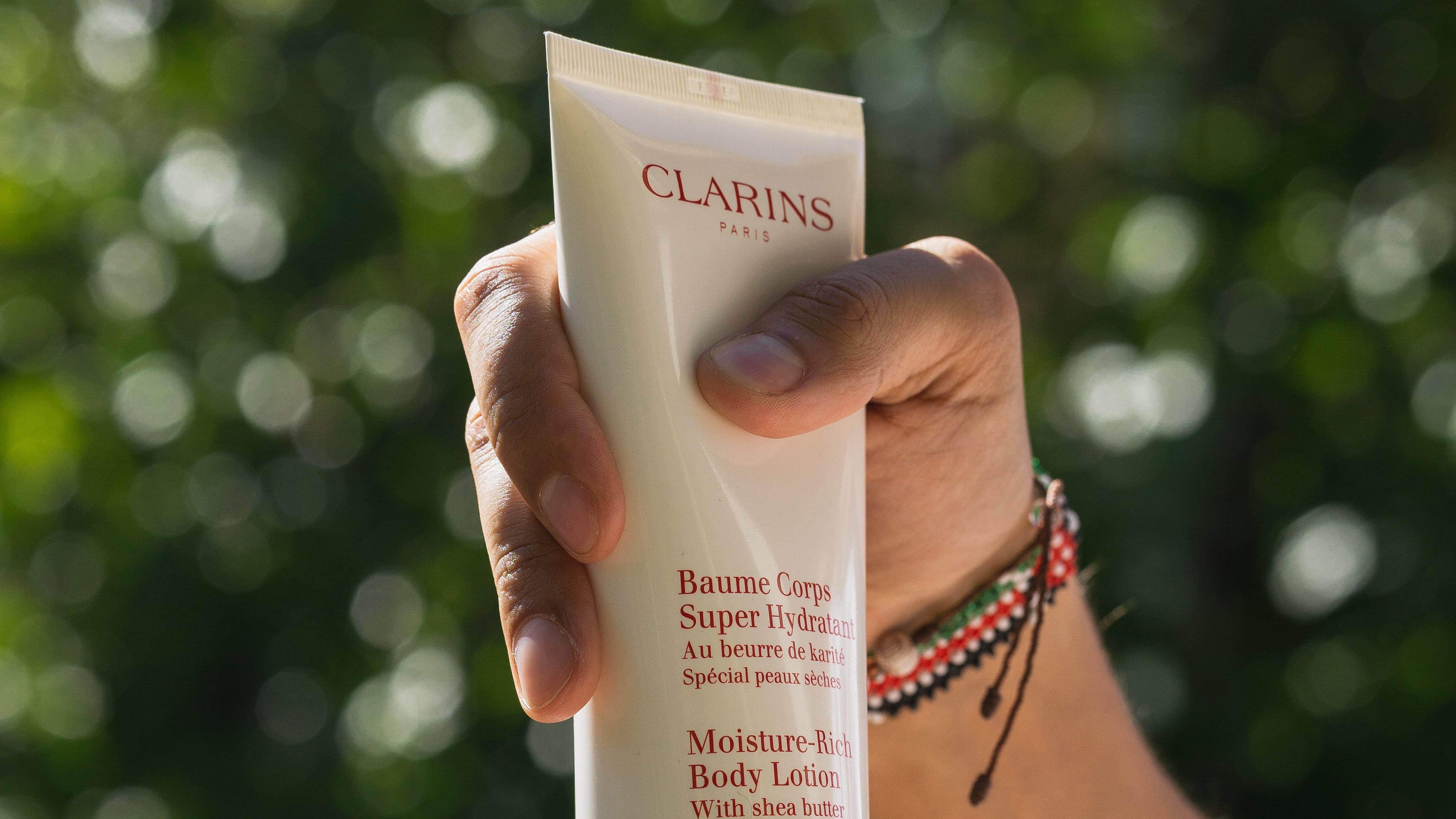 Imagem: mãos femininas segurando bisnaga de creme hidratante em