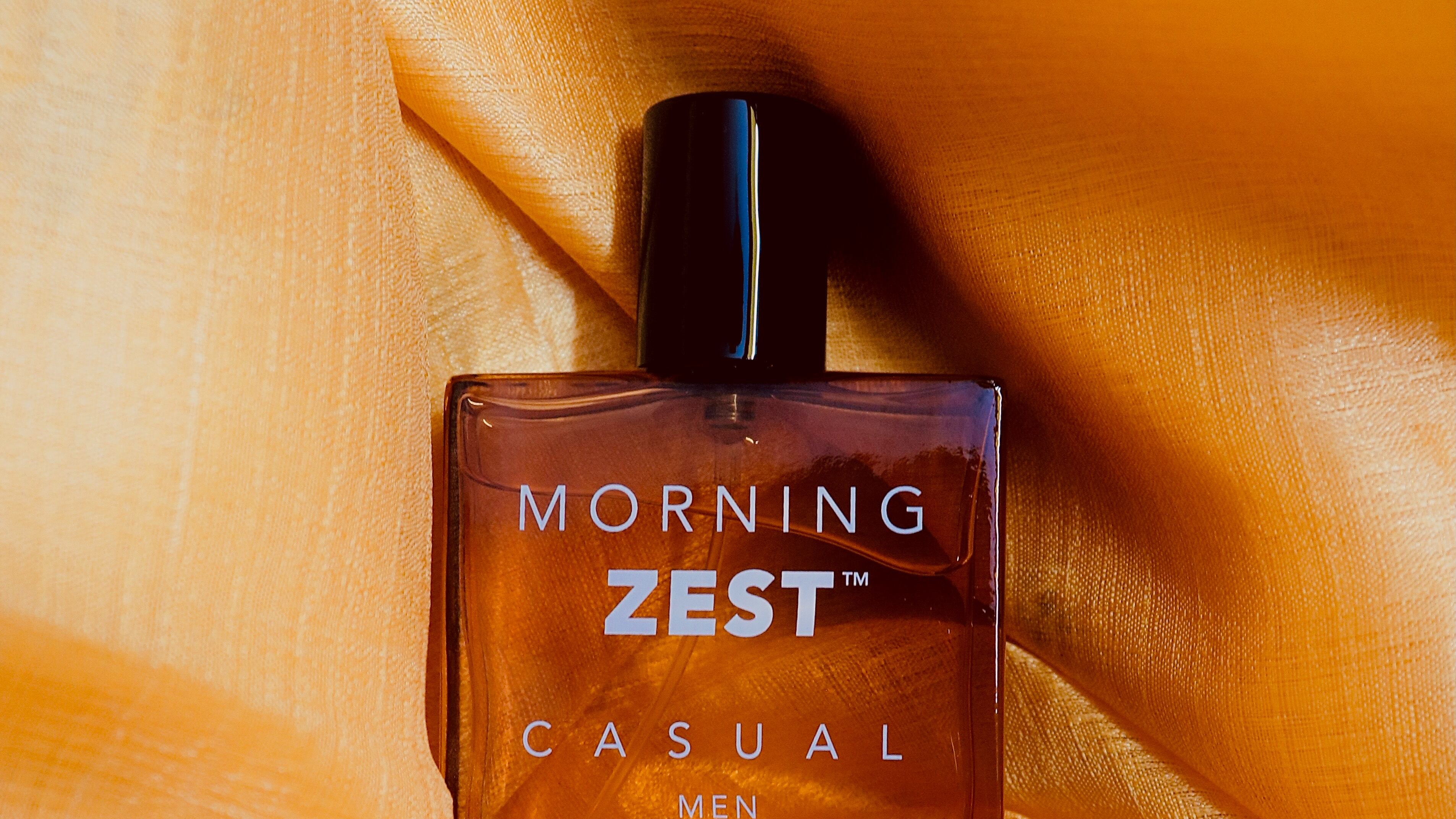 Frasco de perfume envolto de lençol de seda laranja